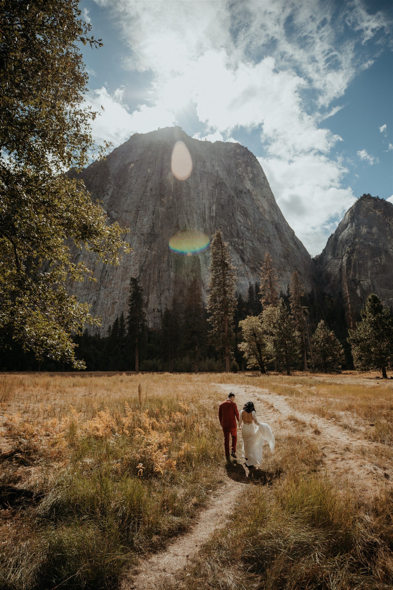 Bride and groom walking through El Capitan Meadow