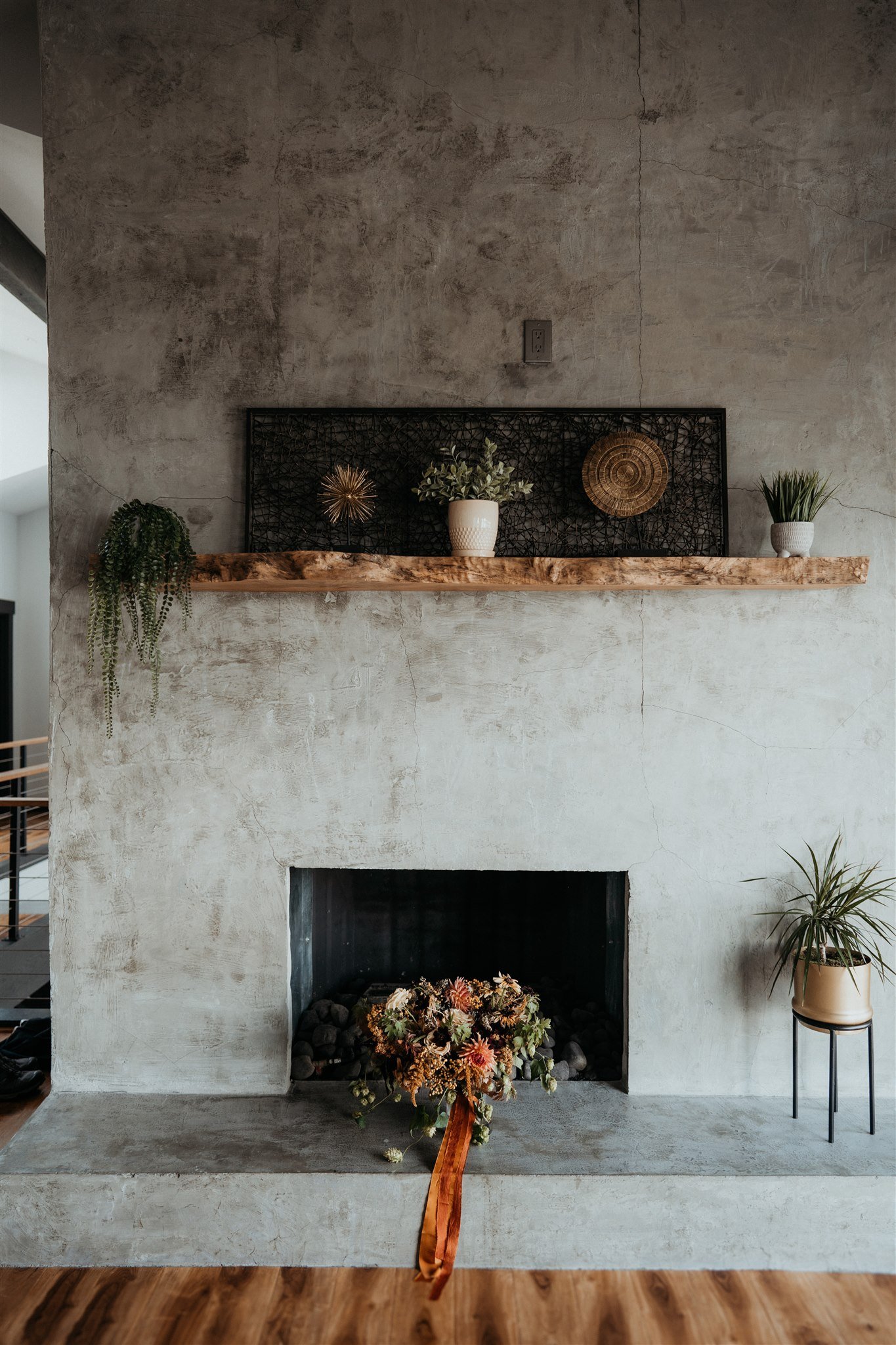 Autumn wedding bouquet sitting in front of concrete fireplace