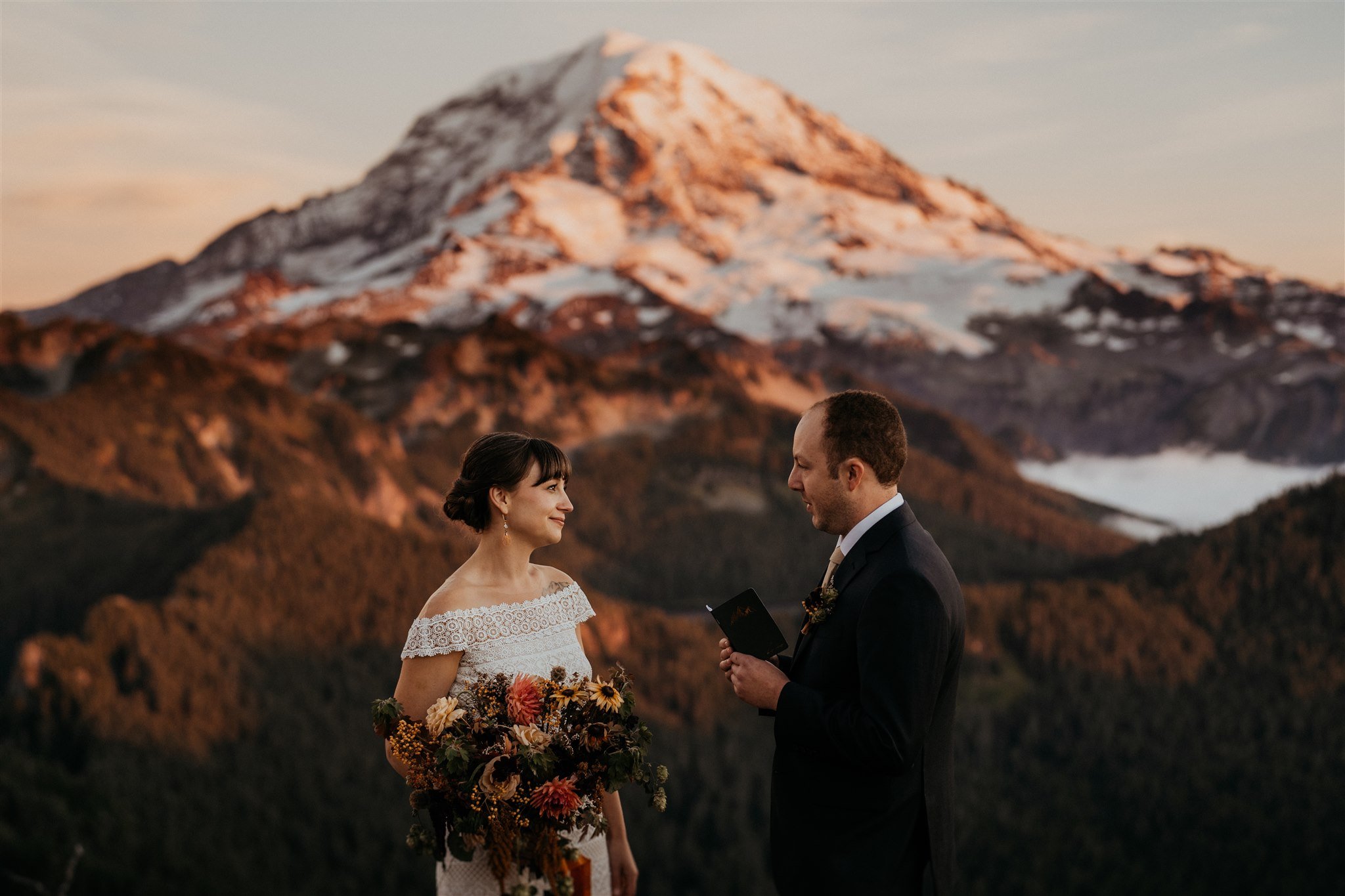 Groom reads vows to bride at autumn wedding in Mt Rainier