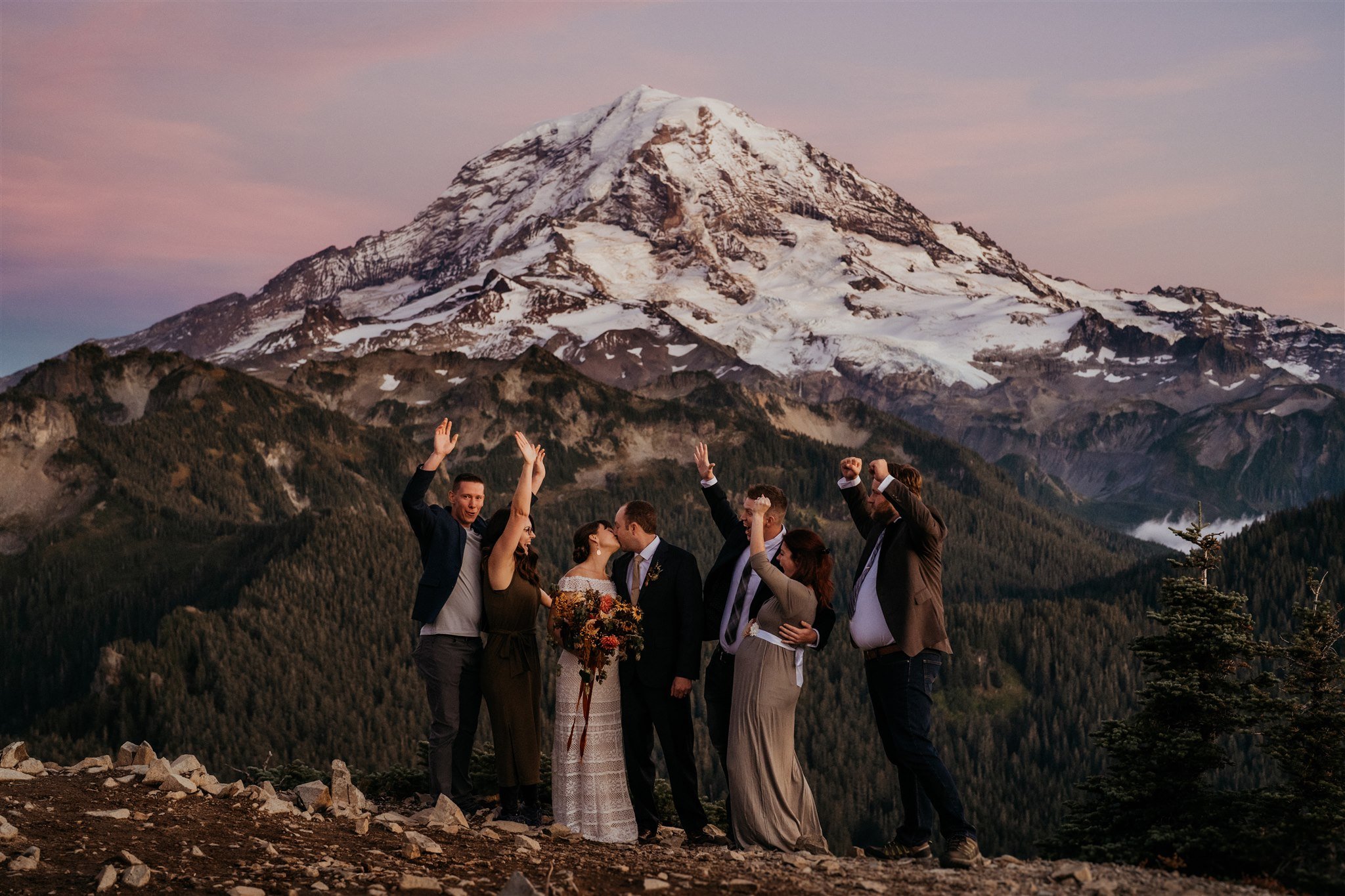 Guests cheer as bride and groom kiss at autumn wedding at Mt Rainier