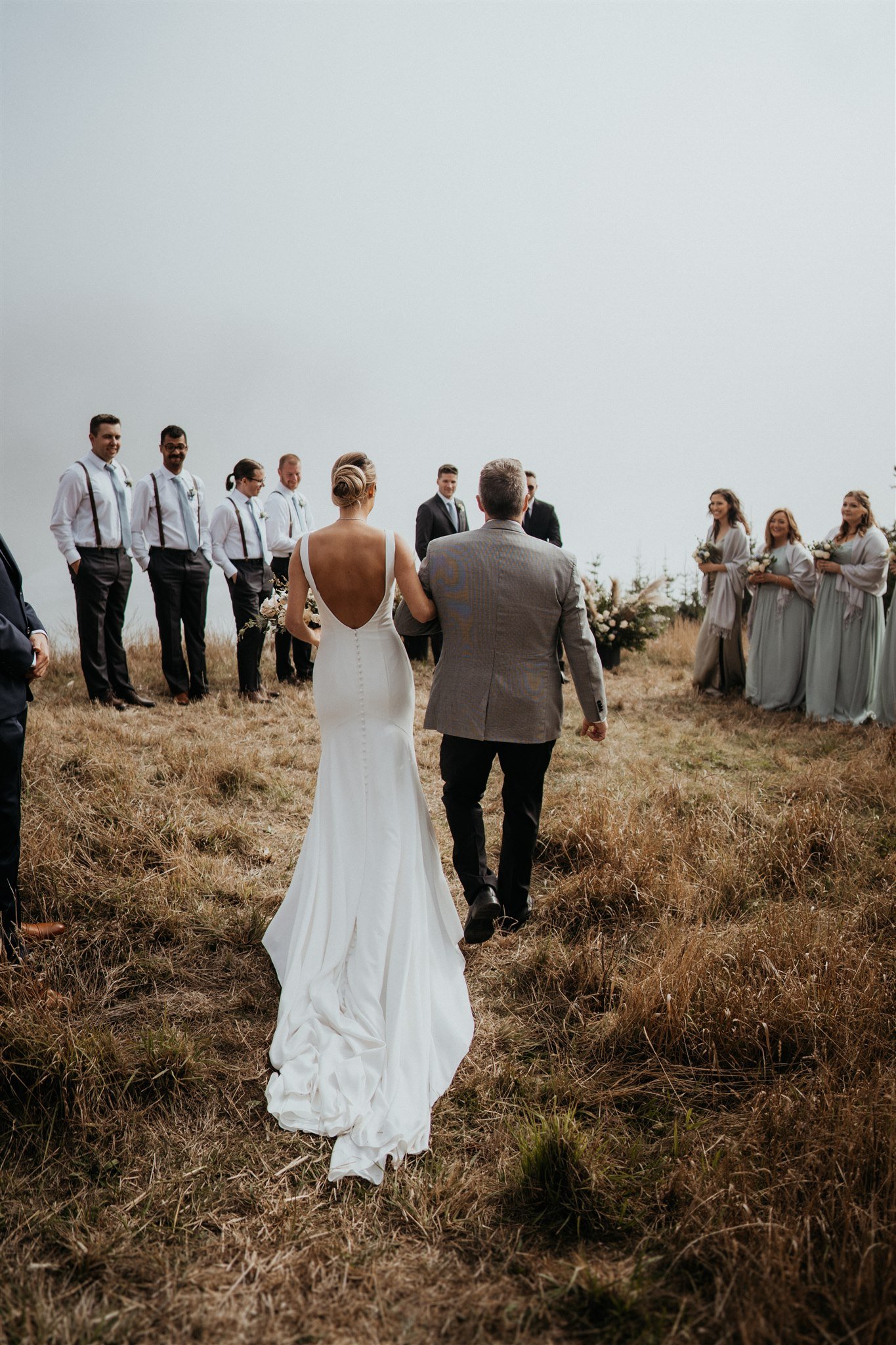 Bride and father arm in arm walking down the aisle for an outdoor intimate wedding ceremony