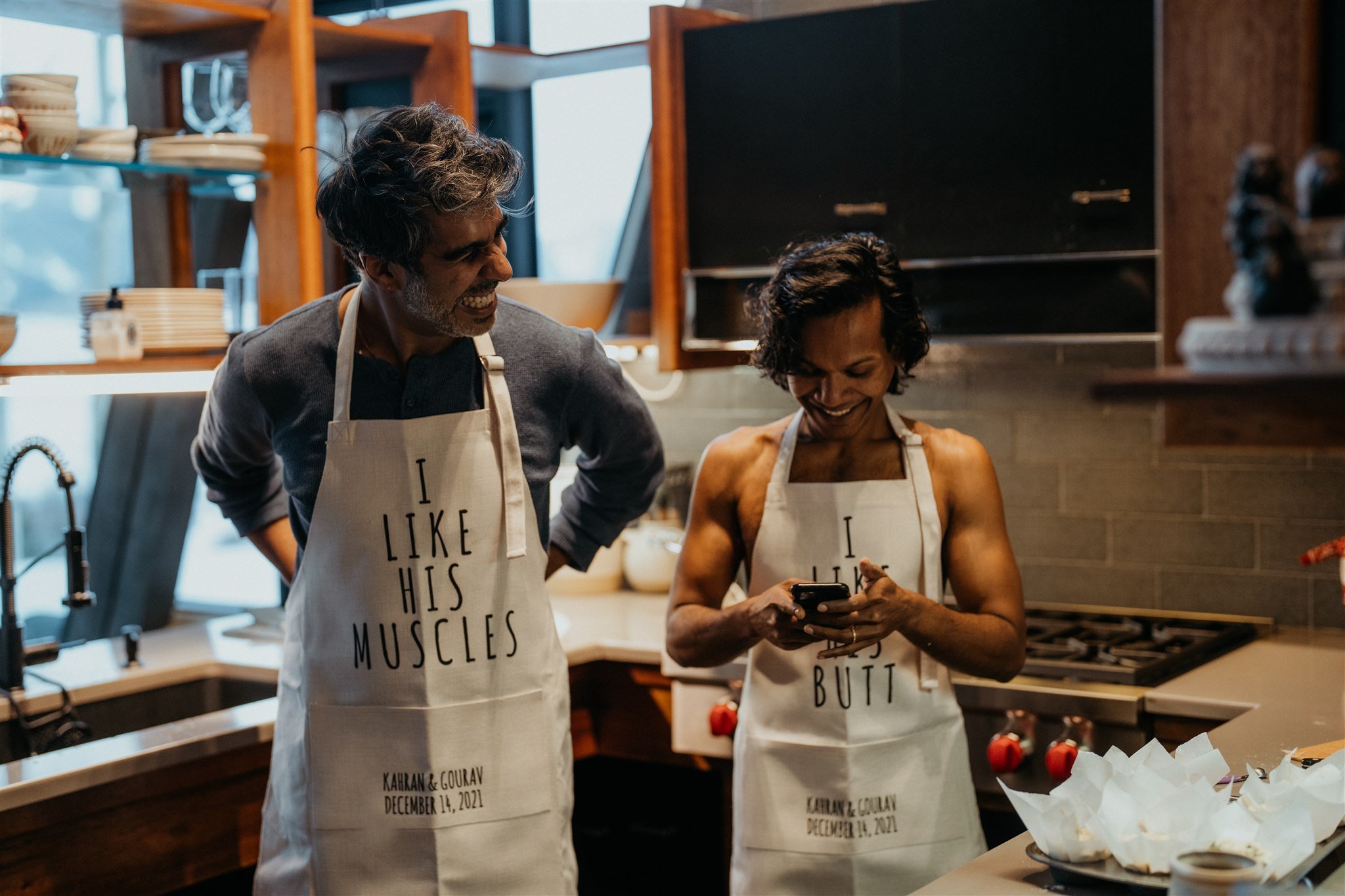 Two grooms in aprons cooking breakfast before their mountain elopement
