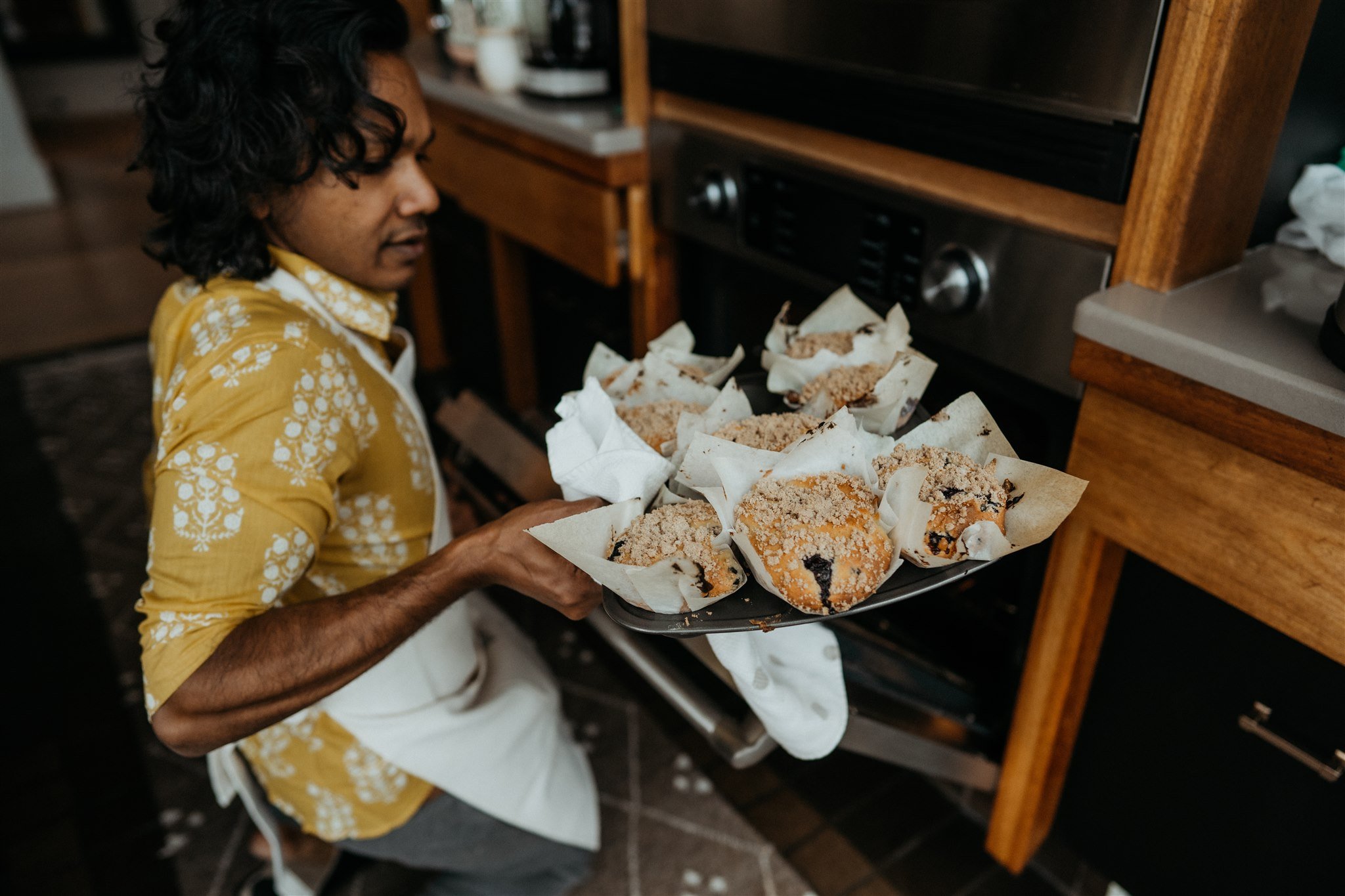 Groom taking baked goods out of the oven 