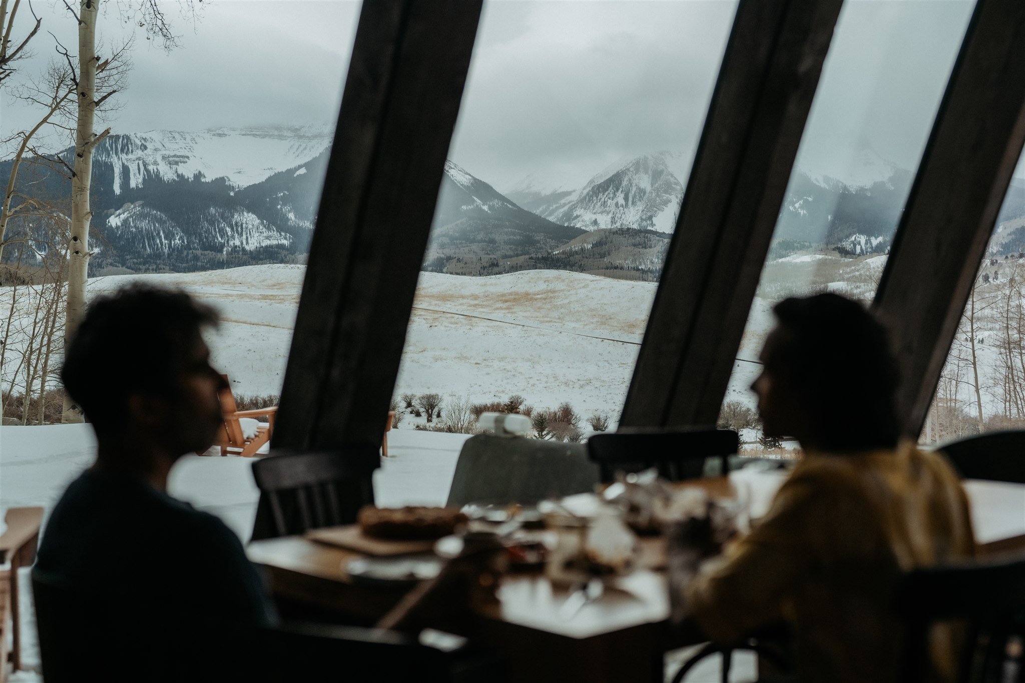 Two grooms eating breakfast before their winter elopement in the Colorado mountains