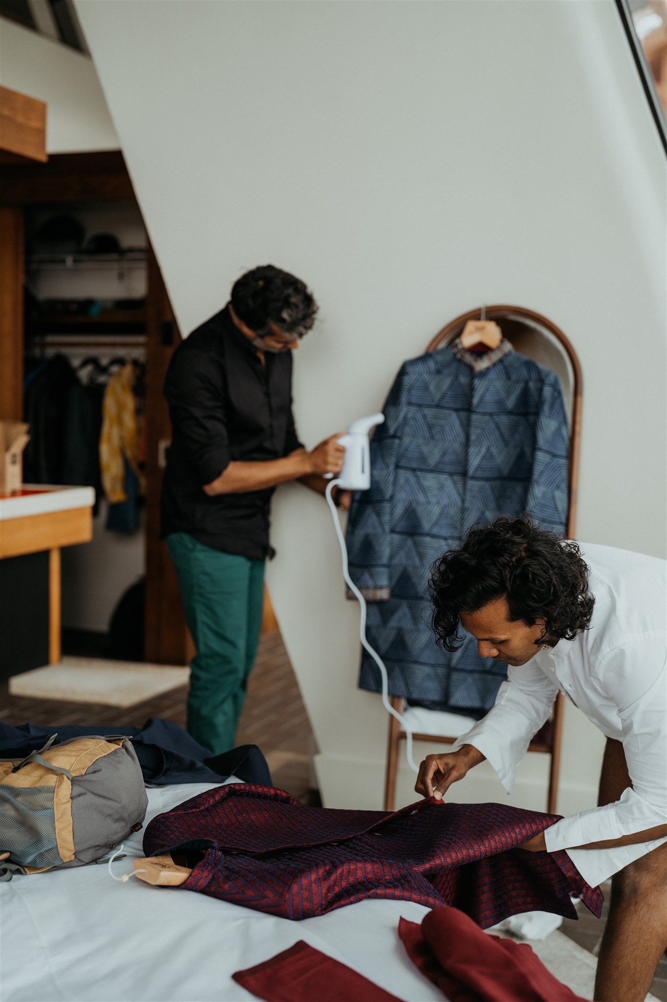 Two grooms preparing wedding outfits for their winter mountain elopement