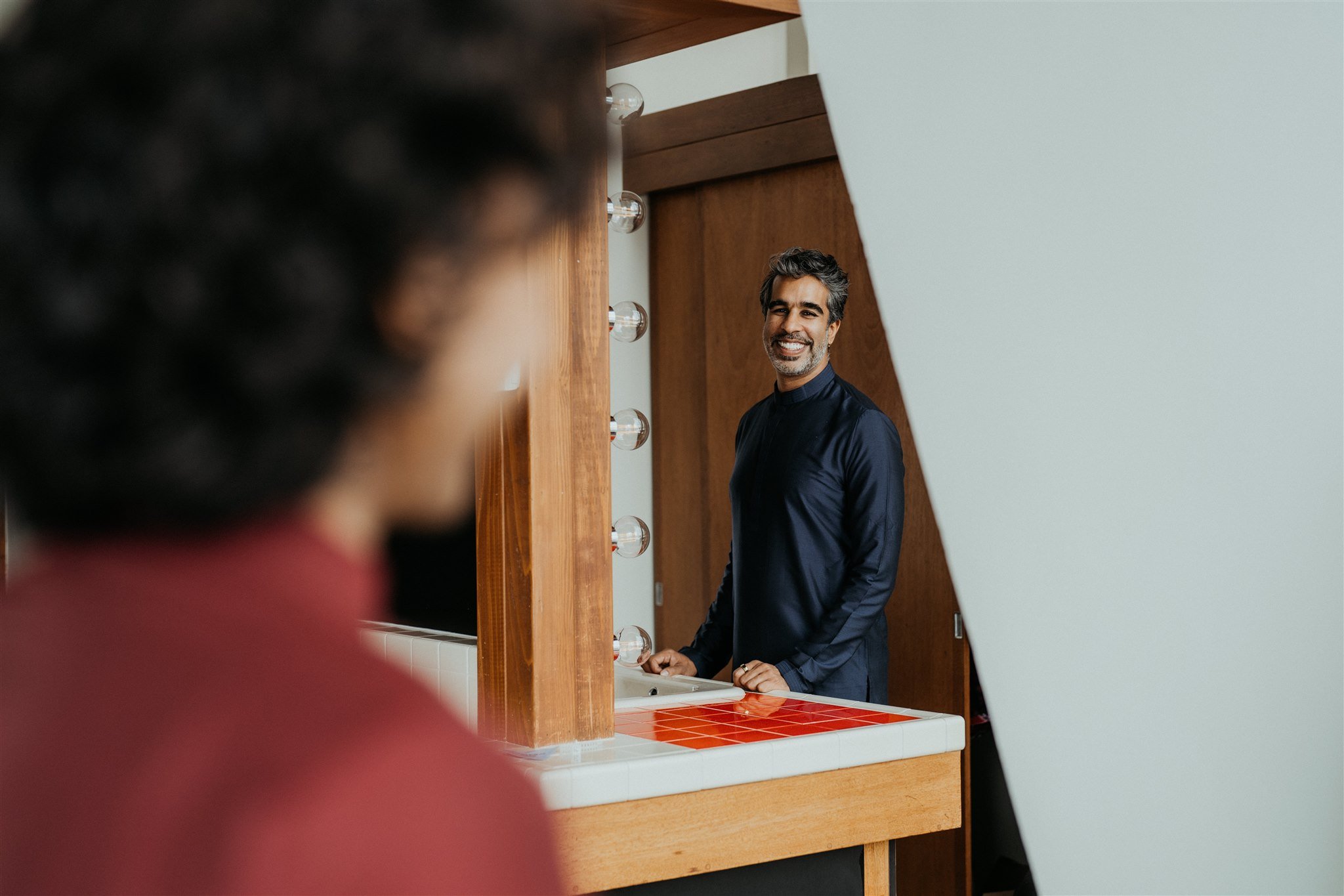 Groom looking and smiling at partner while getting ready for mountain elopement