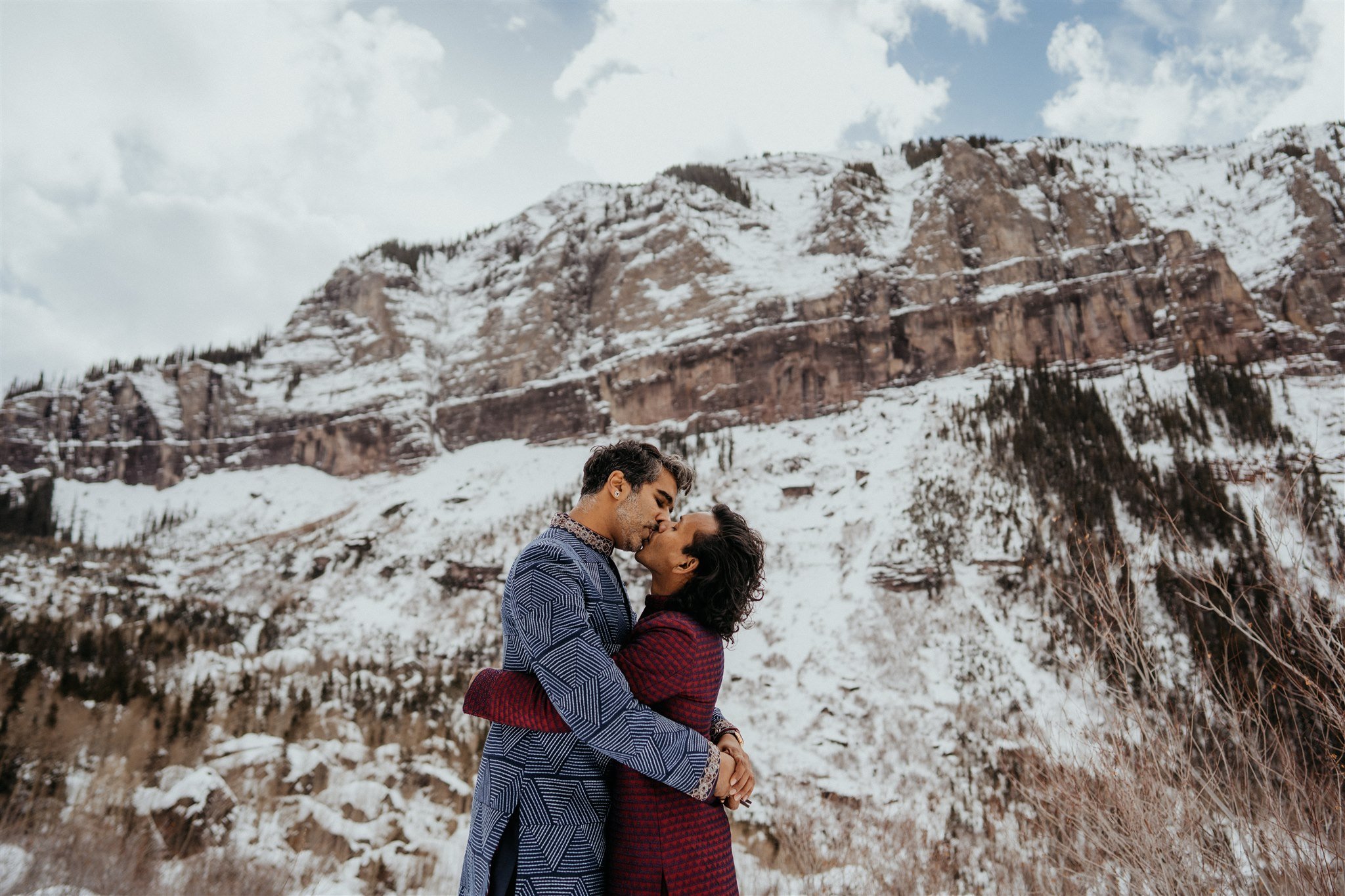 Two grooms kissing at their Colorado mountain elopement