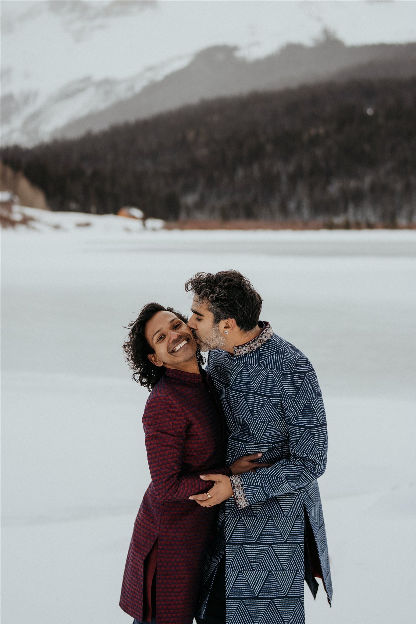 Groom kissing partner's cheek after winter elopement in the Colorado mountains