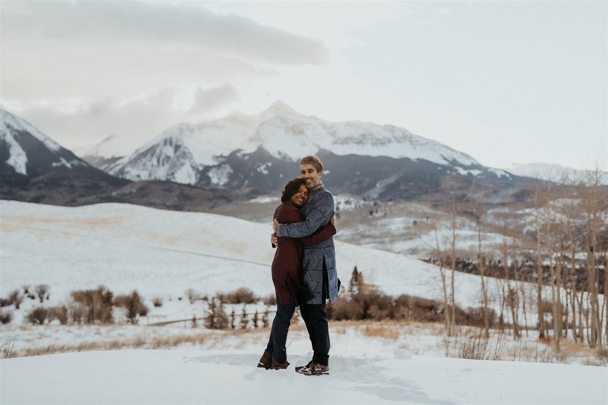 Two grooms hugging after their winter elopement in the Colorado mountains