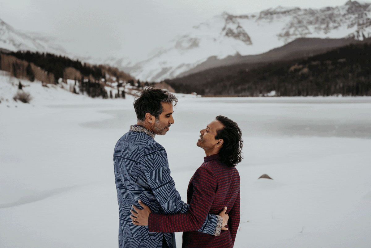 Two grooms kissing at their winter elopement in the Colorado mountains