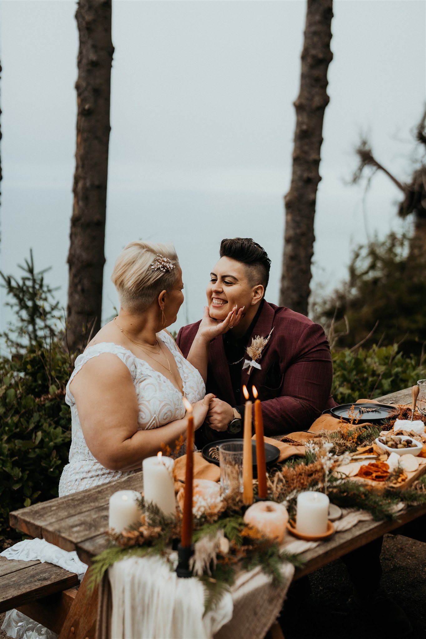 Two brides sitting at the reception table after their PNW elopement ceremony
