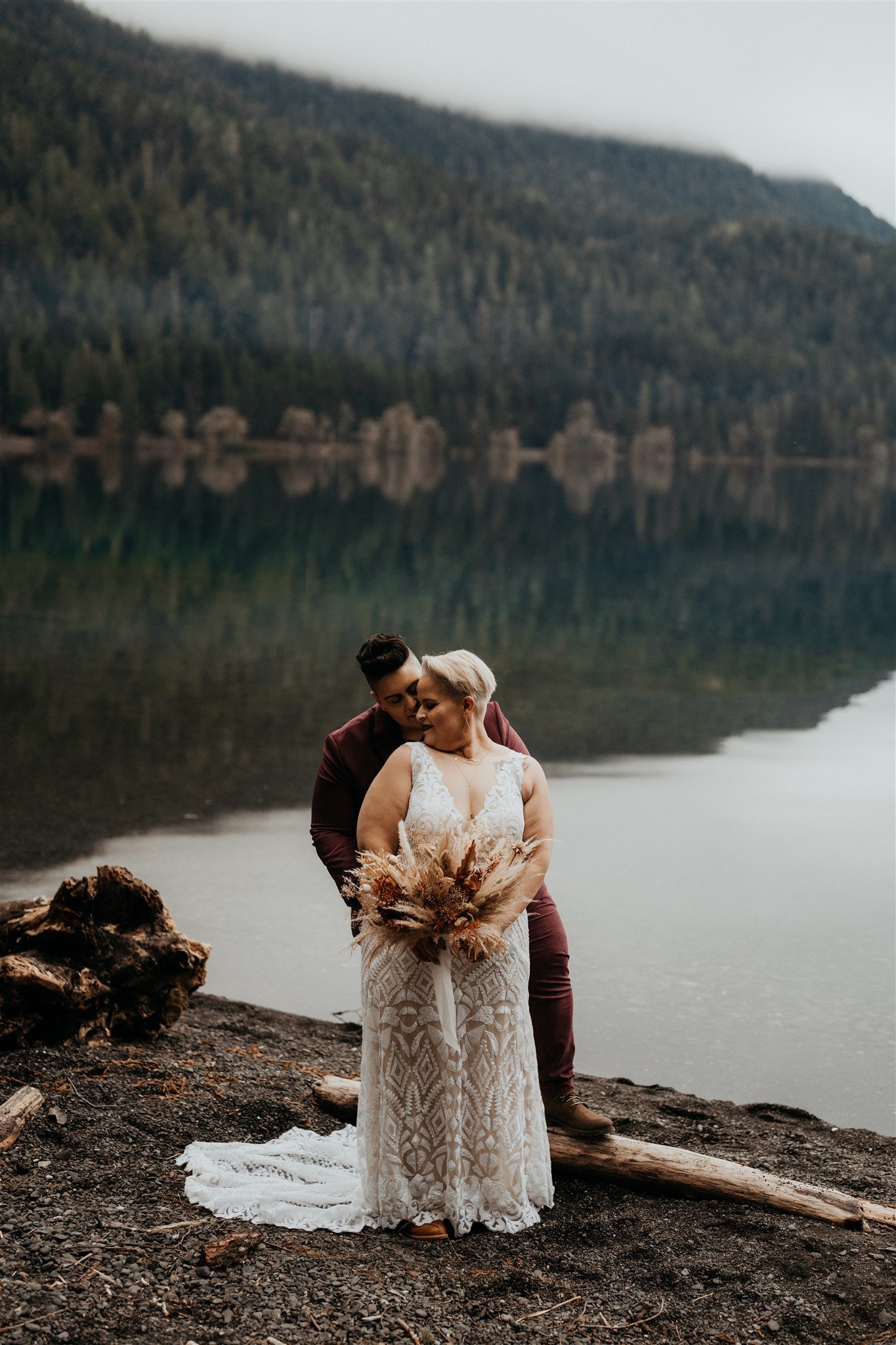 Two brides embracing during autumn elopement in La Push