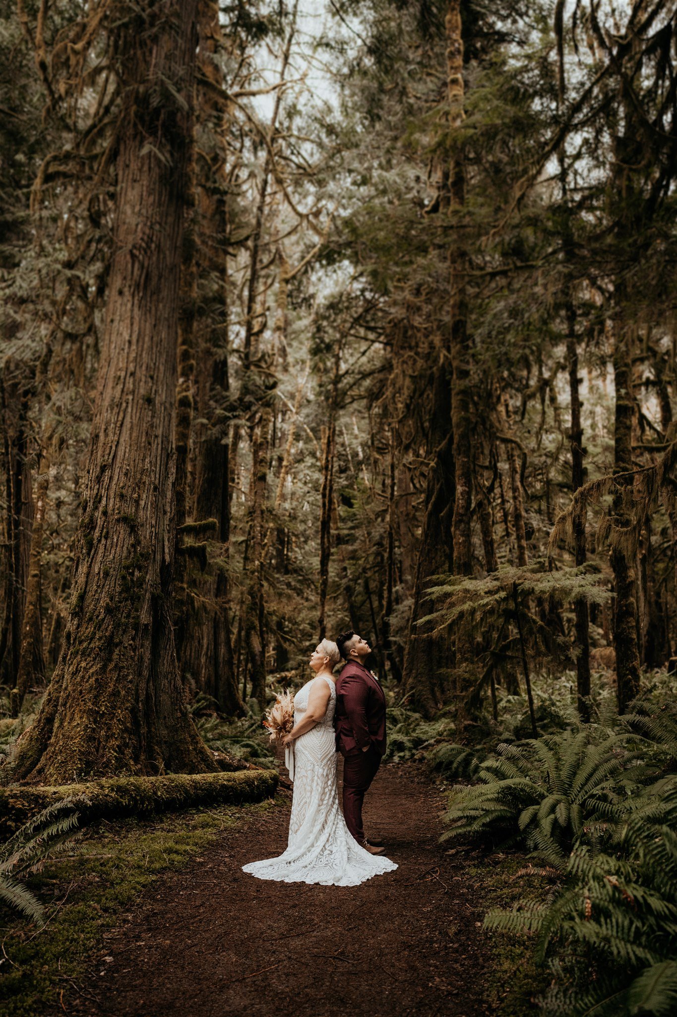 Two brides hugging in a forest in the Olympic National Park