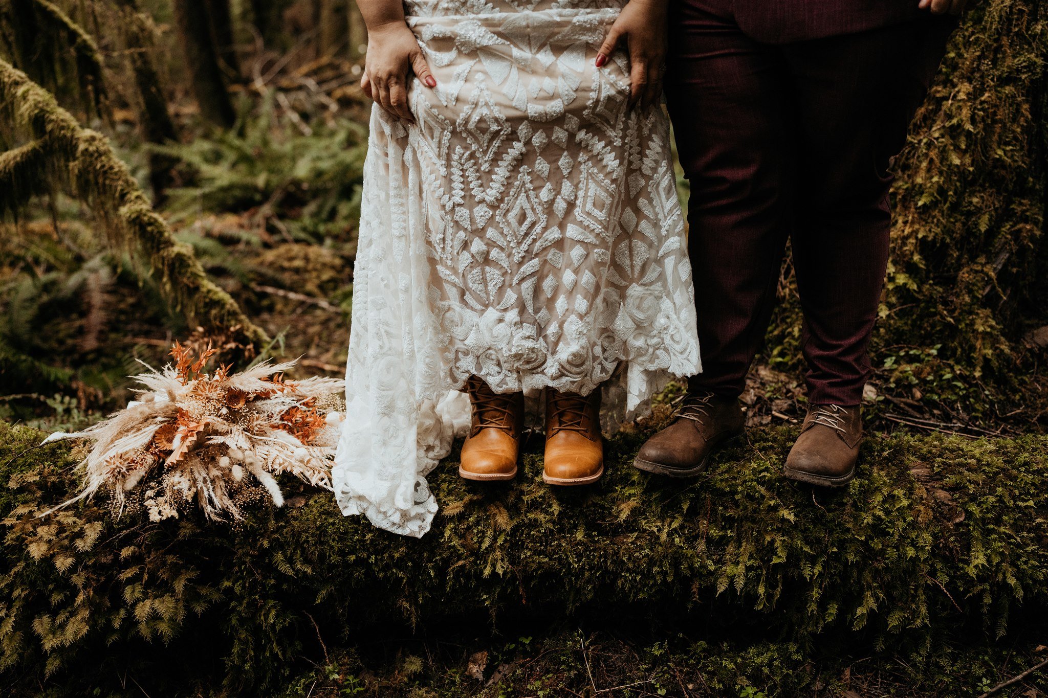 Two brides standing on a log with autumn elopement bouquet 