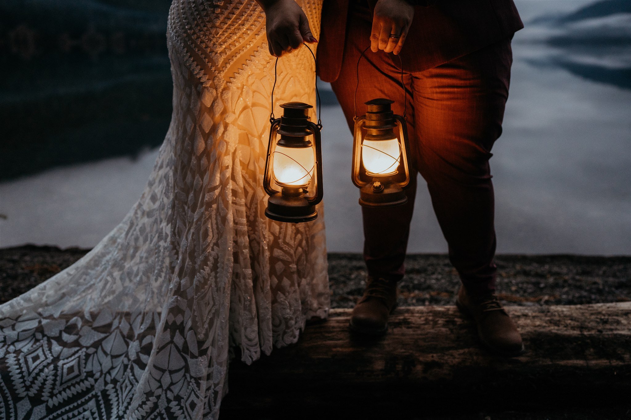 Two brides holding lanterns at the beach in Olympic National Park