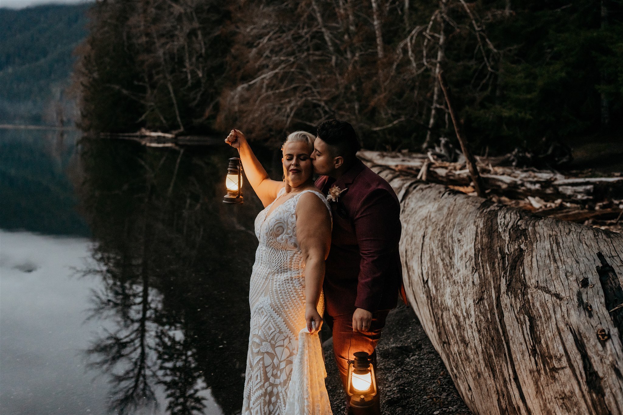 Two brides holding lanterns for beach elopement photos in the PNW