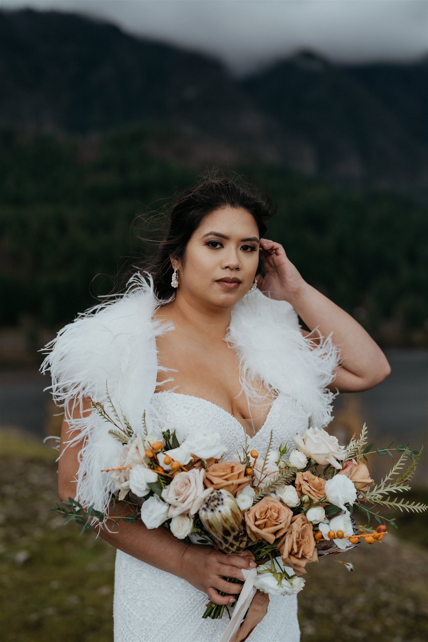 Bride holding white, rust and rose colored wedding bouquet
