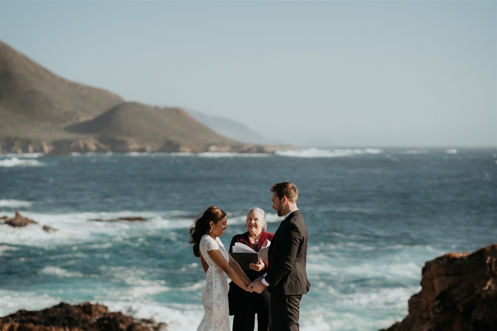 Bride and groom holding hands during Big Sur elopement ceremony