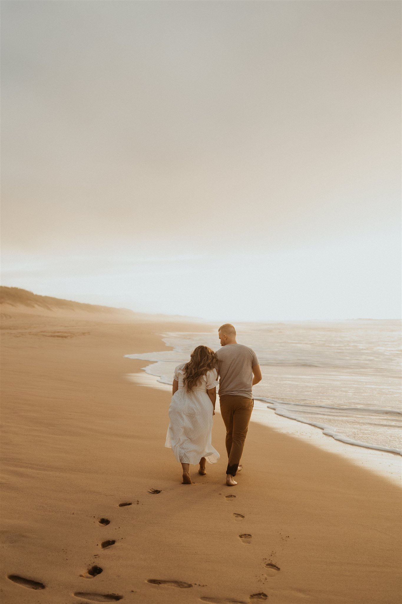 Couple walking along the beach during Hawaii engagement photo session