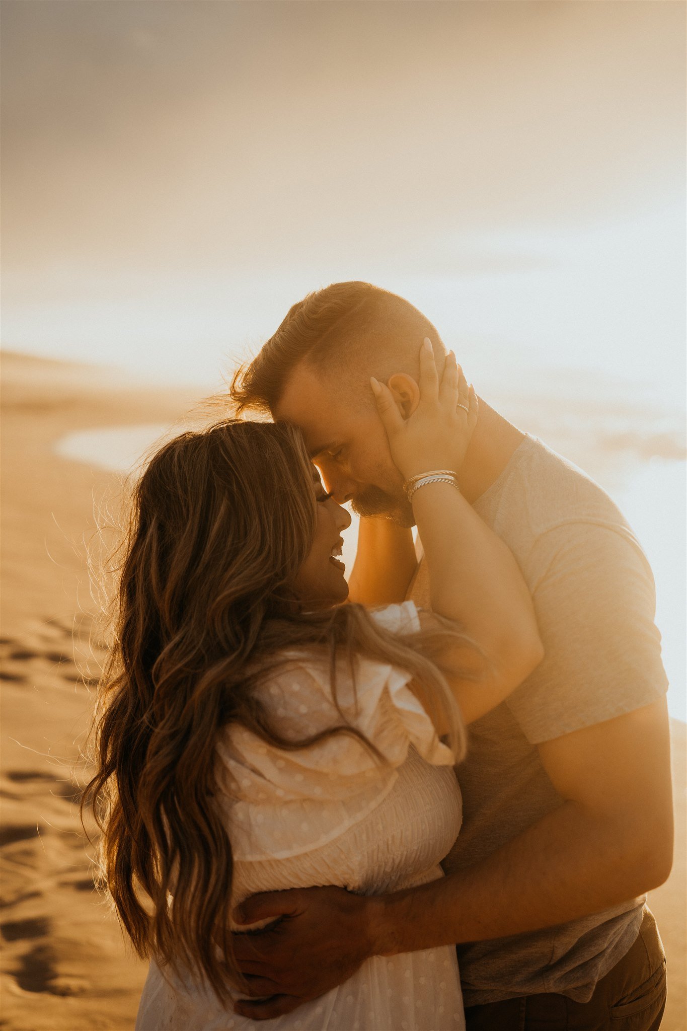 Couple hugging on the beach in Kauai during Hawaii engagement photos