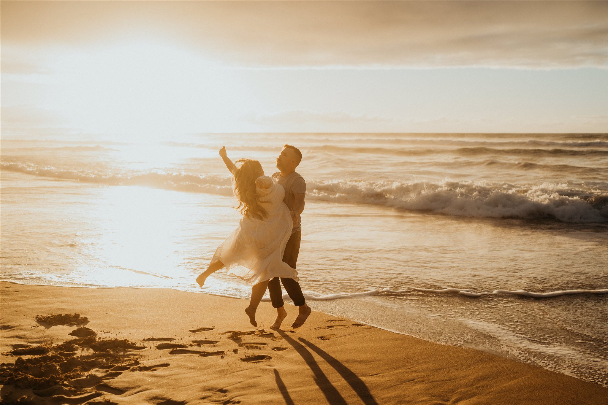 Couple chest bumping on the beach in Kauai during Hawaii engagement photo session