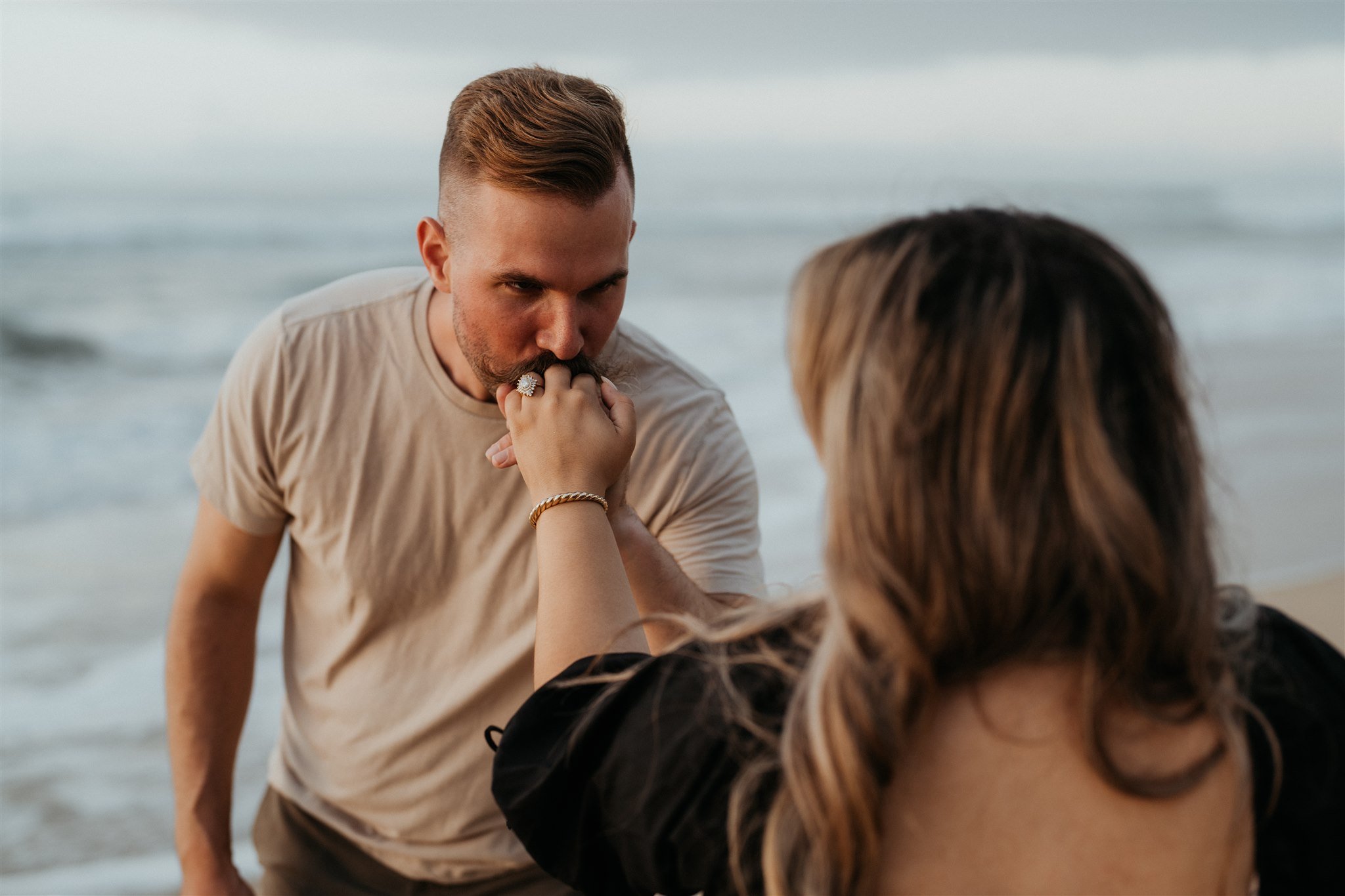 Man kissing woman's hand during Hawaii engagement photos