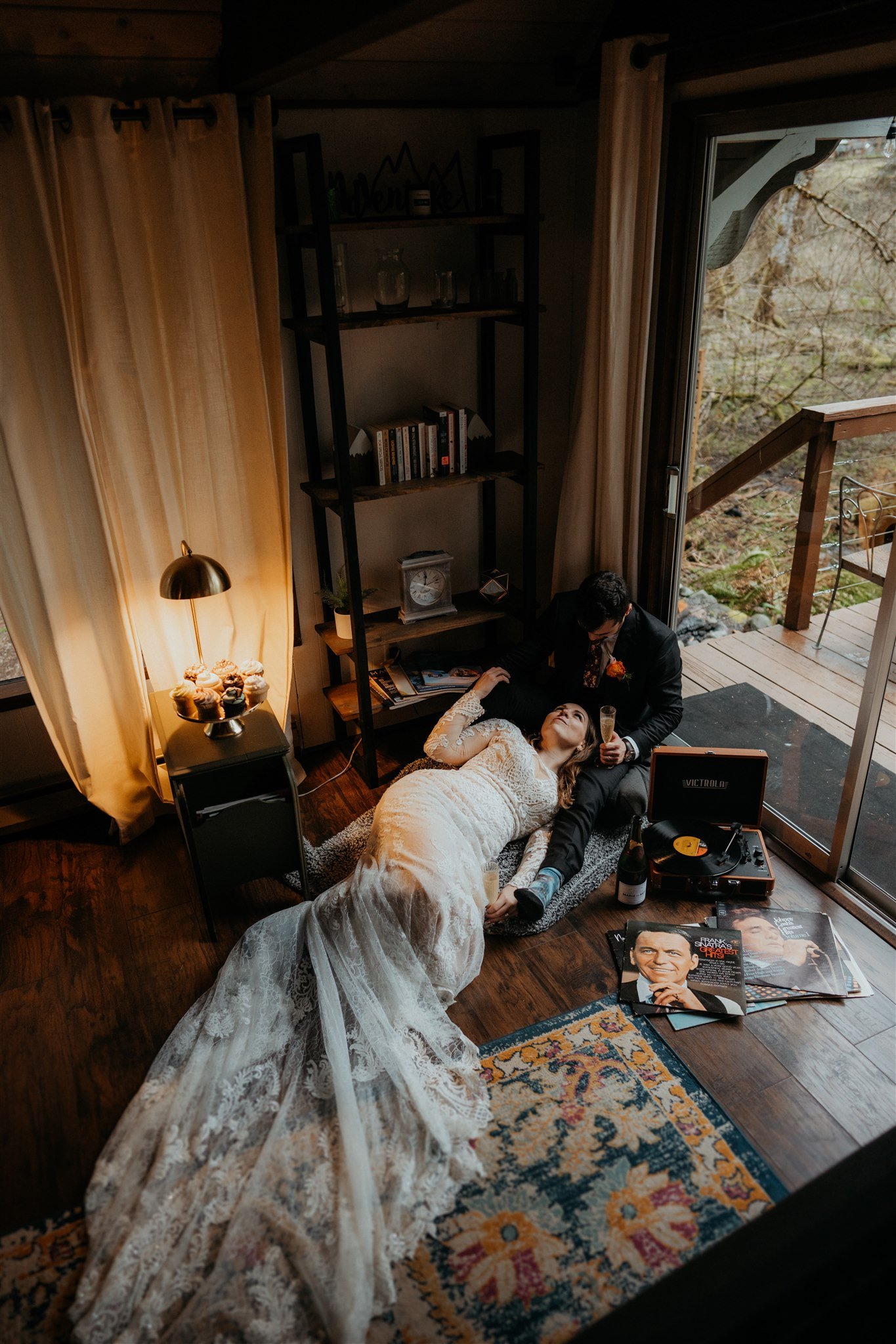 Bride and groom laying on the floor eating a cheese board after their snowy mountain elopement in Washington