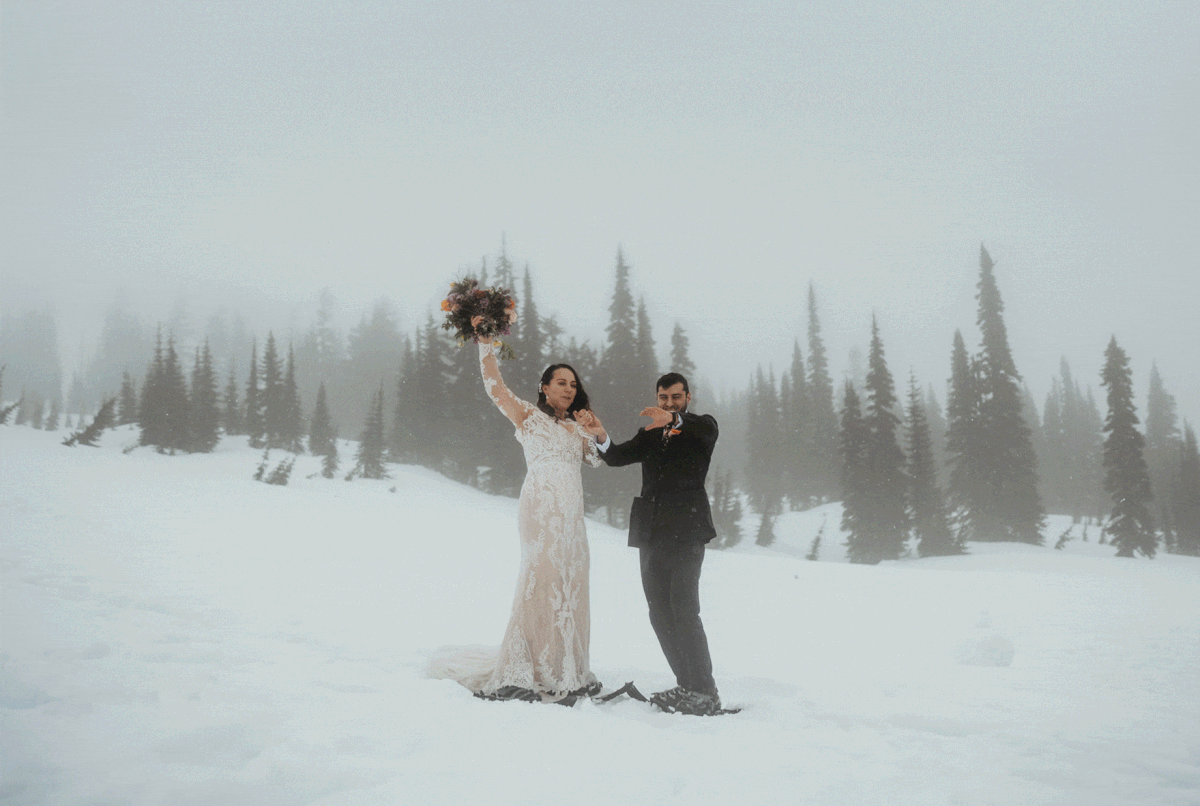 Bride and groom cheering in front of Mt Rainier during their hiking elopement ceremony