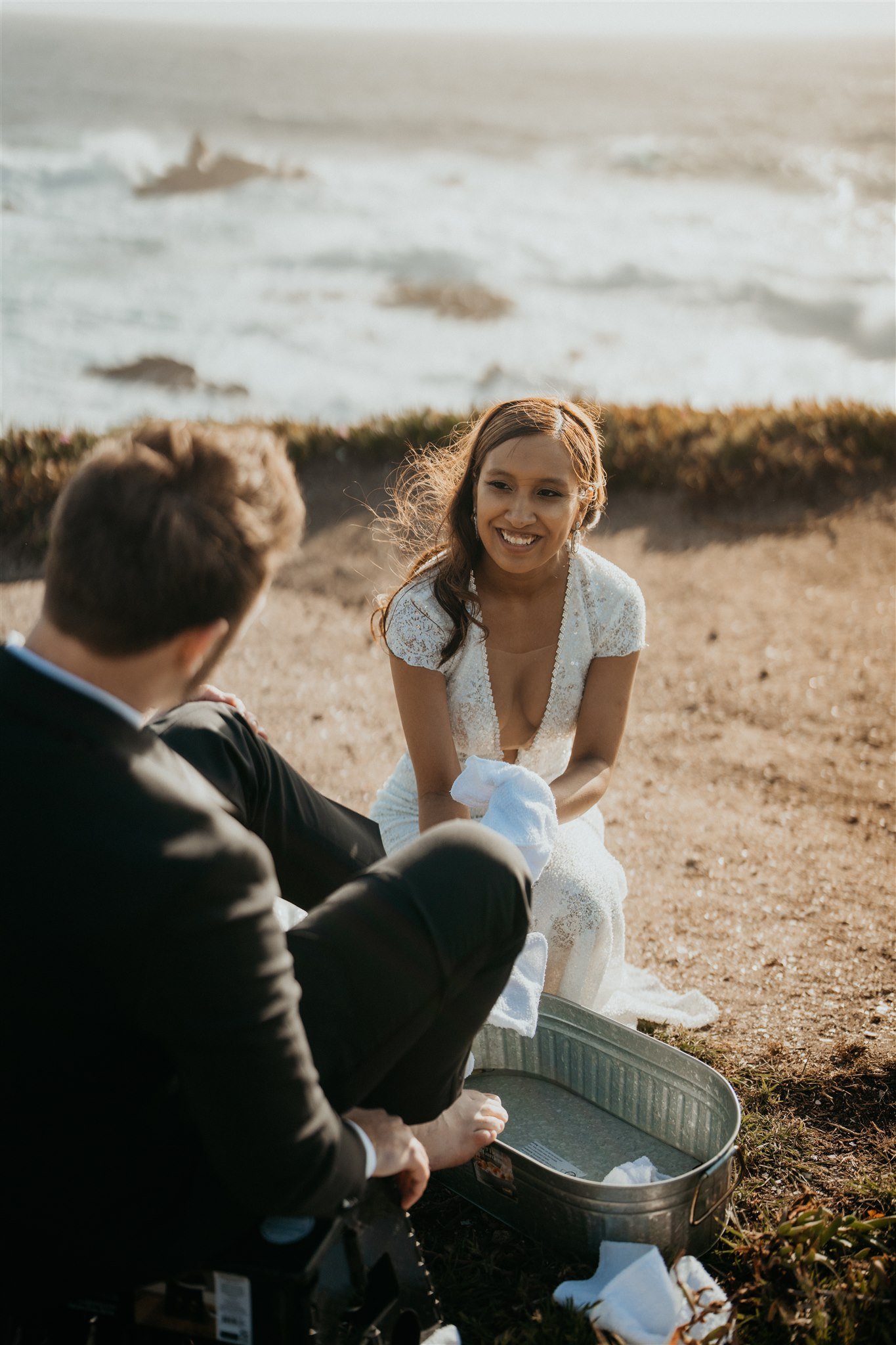 Bride washes groom's feet during wedding ceremony at Big Sur