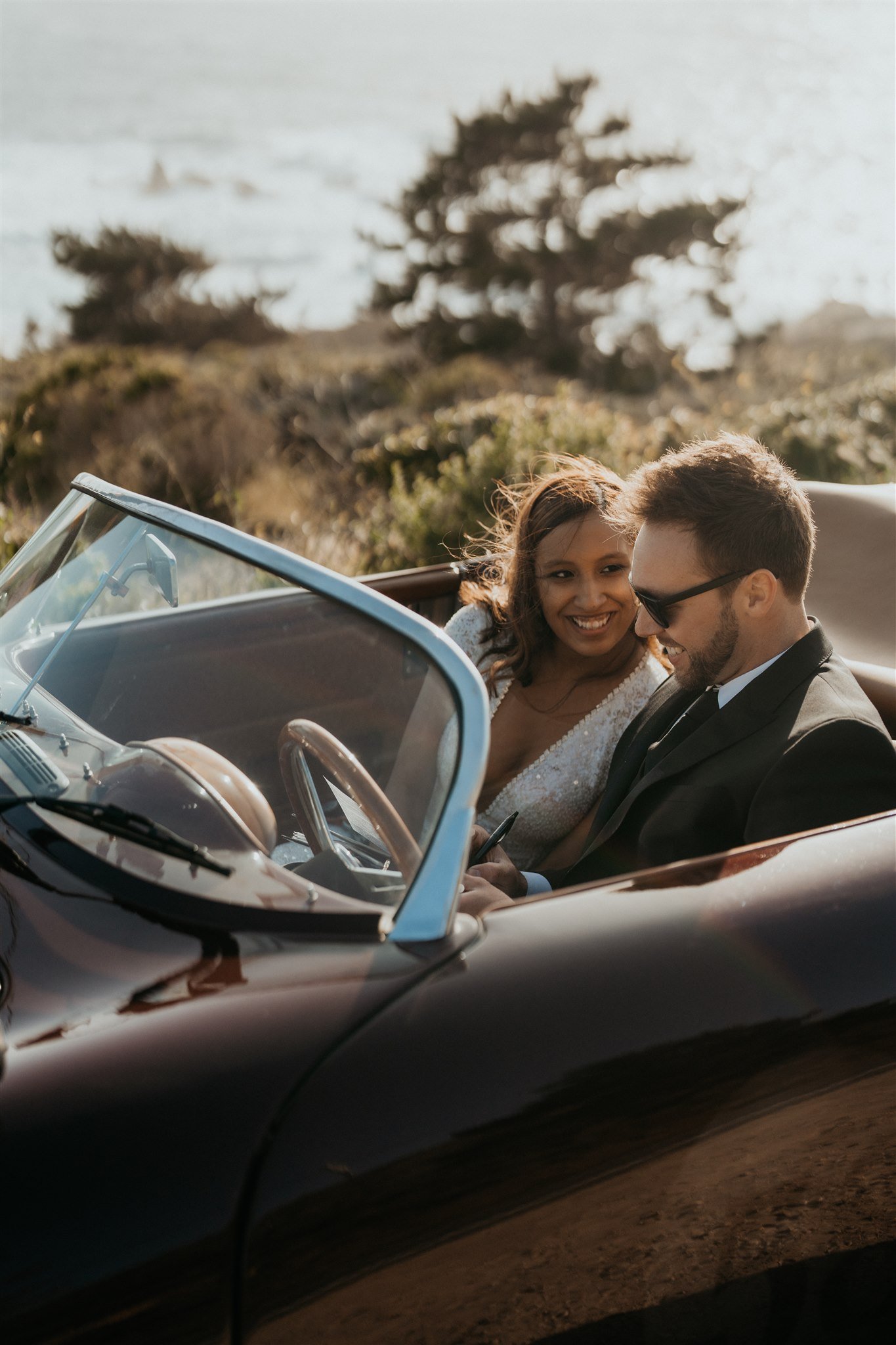Bride and groom sitting in vintage convertible during Big Sur elopement