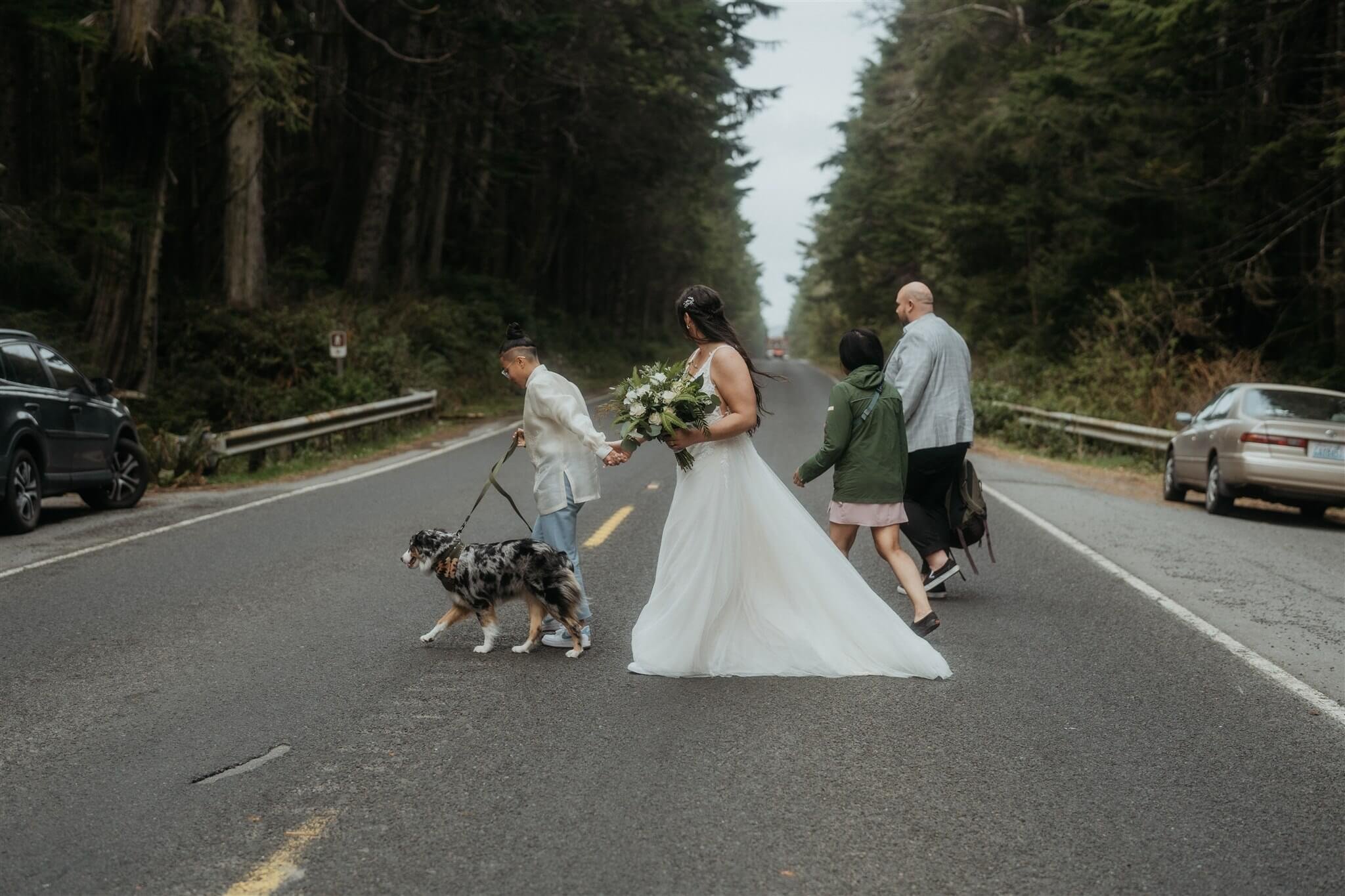 Two brides walking dog across the road to their Ruby Beach elopement