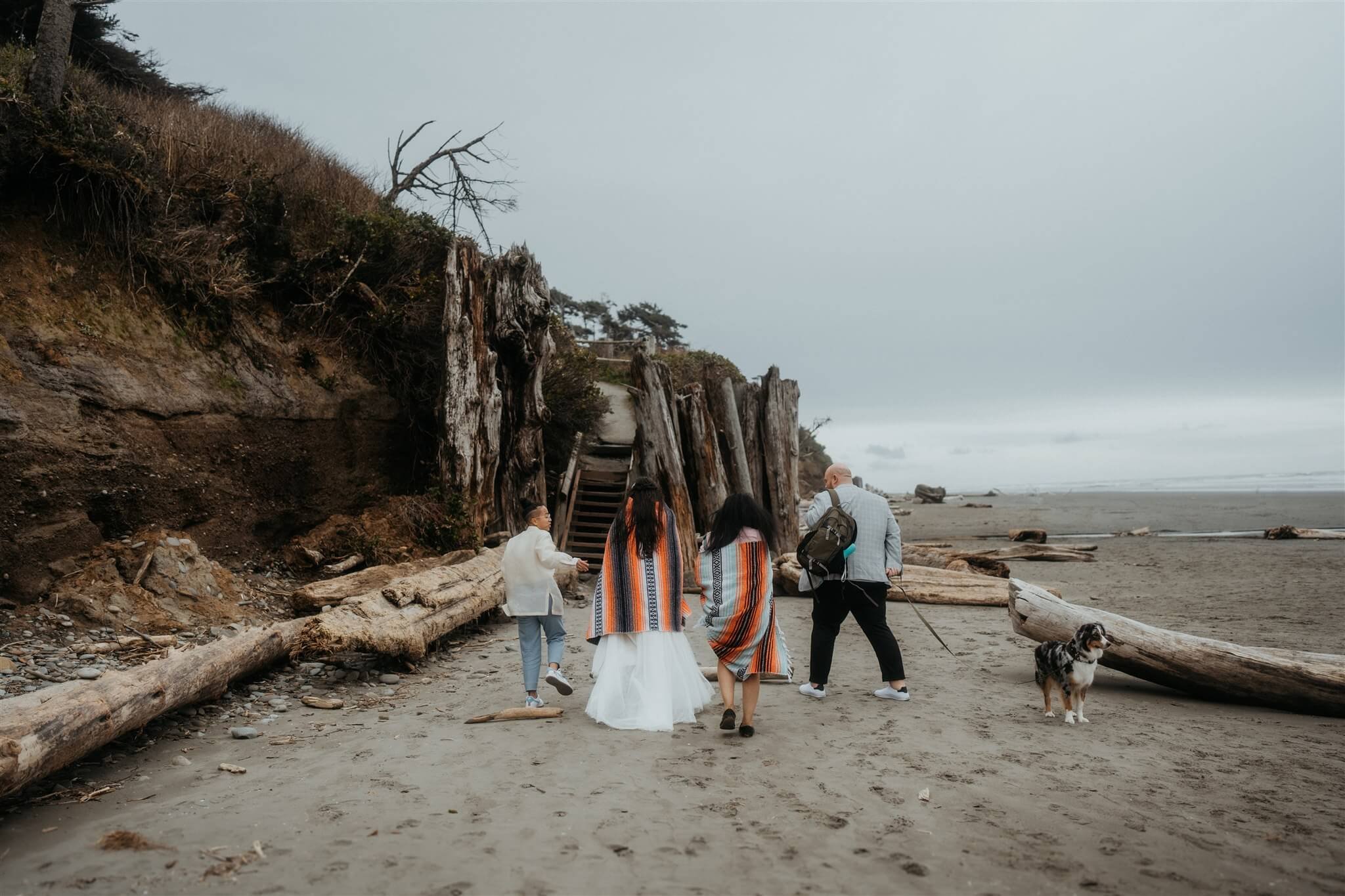 Two brides and friends walking along the beach in Olympic National Park