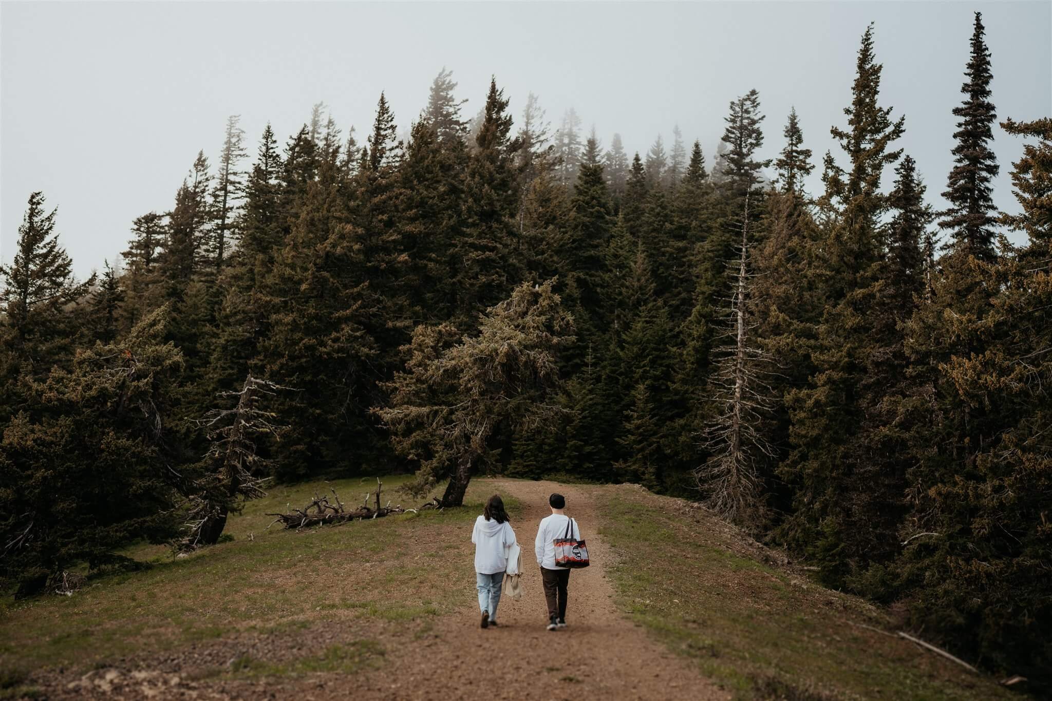 Couple walking down the hiking trail for anniversary session at Red Top Lookout