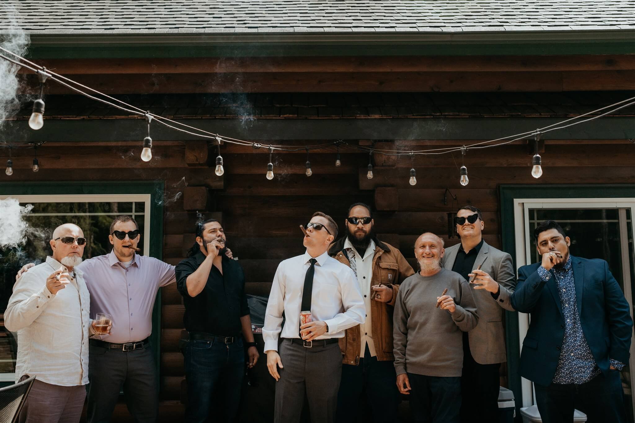 Groom smoking cigar with family and friends