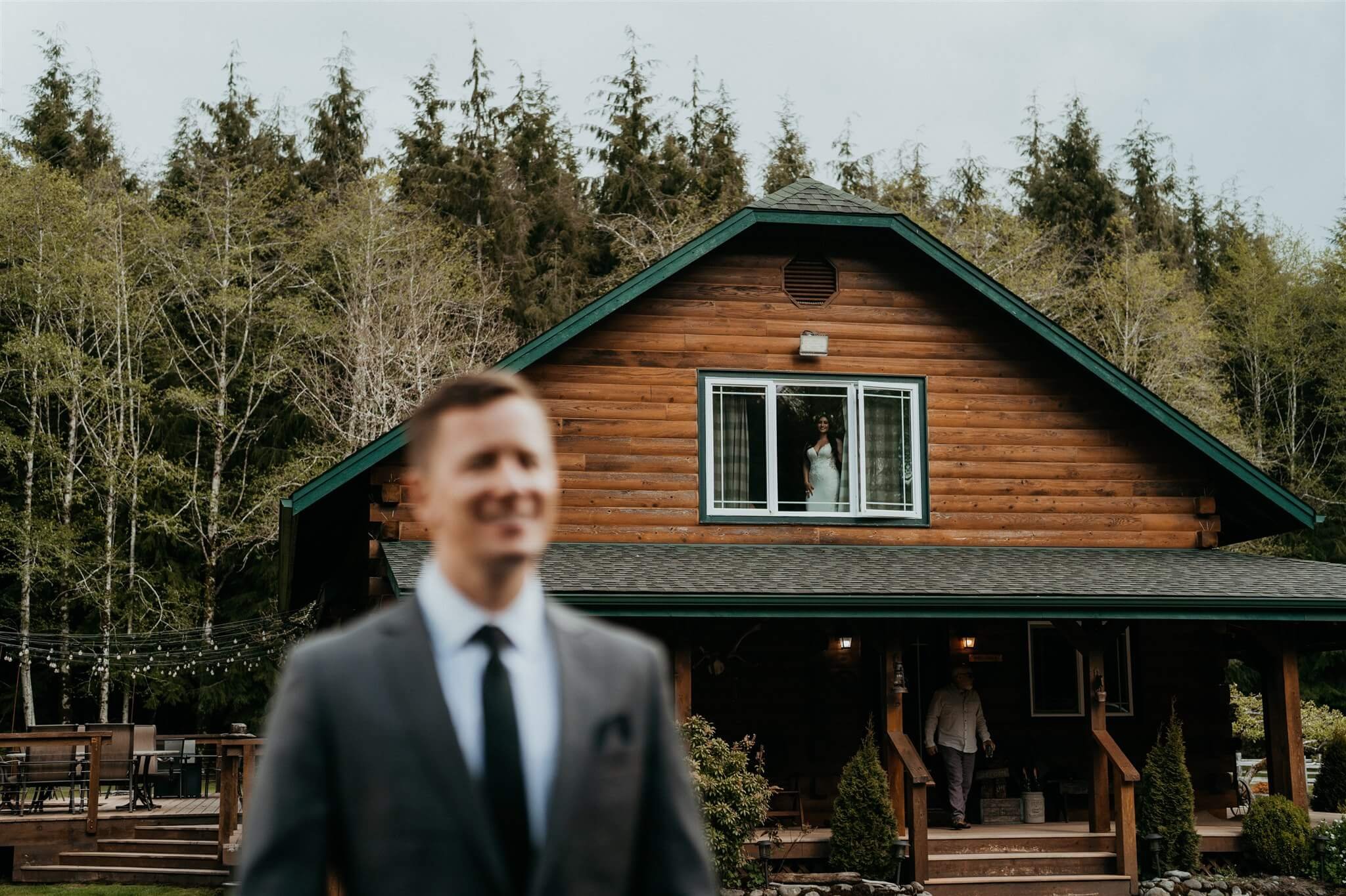 Bride looking out the window of cabin in the Olympic Peninsula