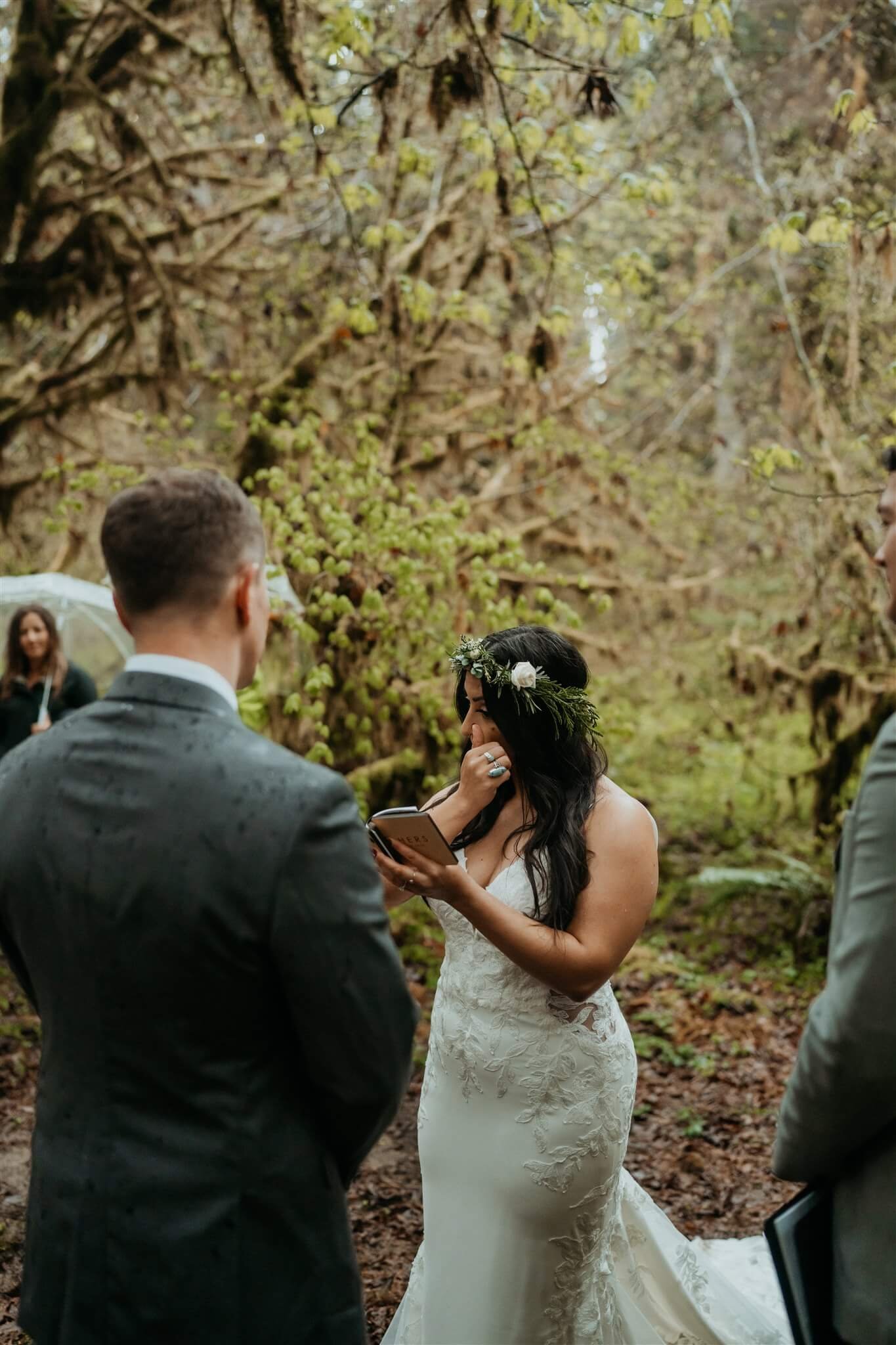 Bride tearing up while reading vows in the forest