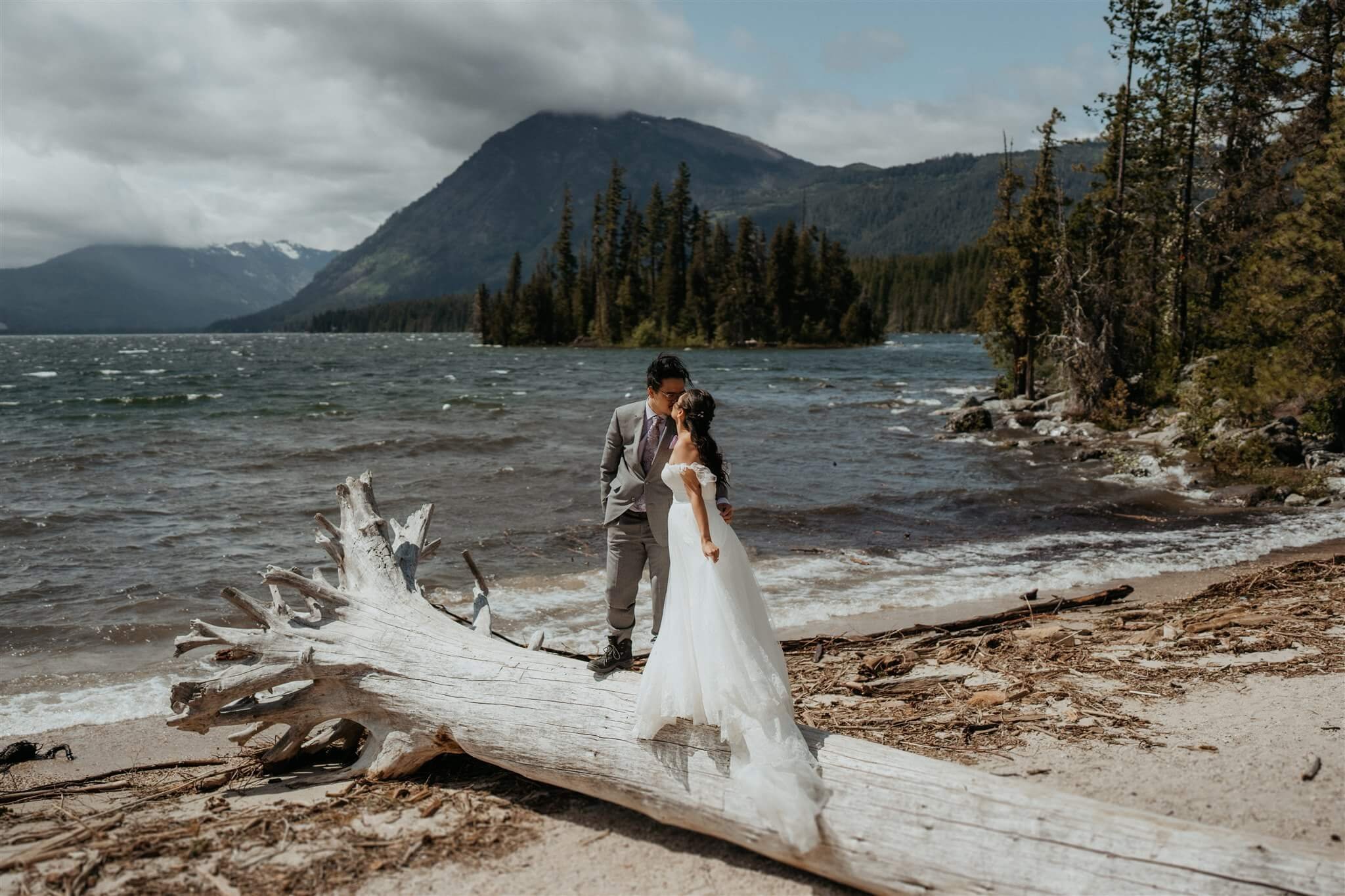 Bride and groom kiss by the lake in the North Cascades