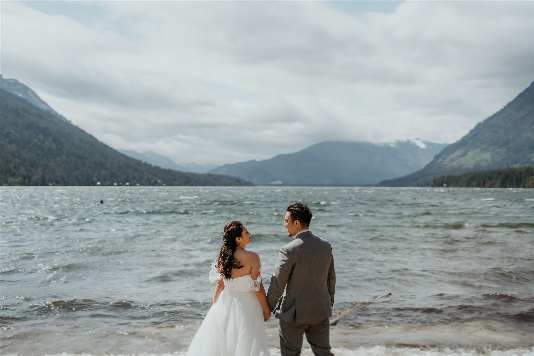 Bride and groom hold hands by Barclay Lake