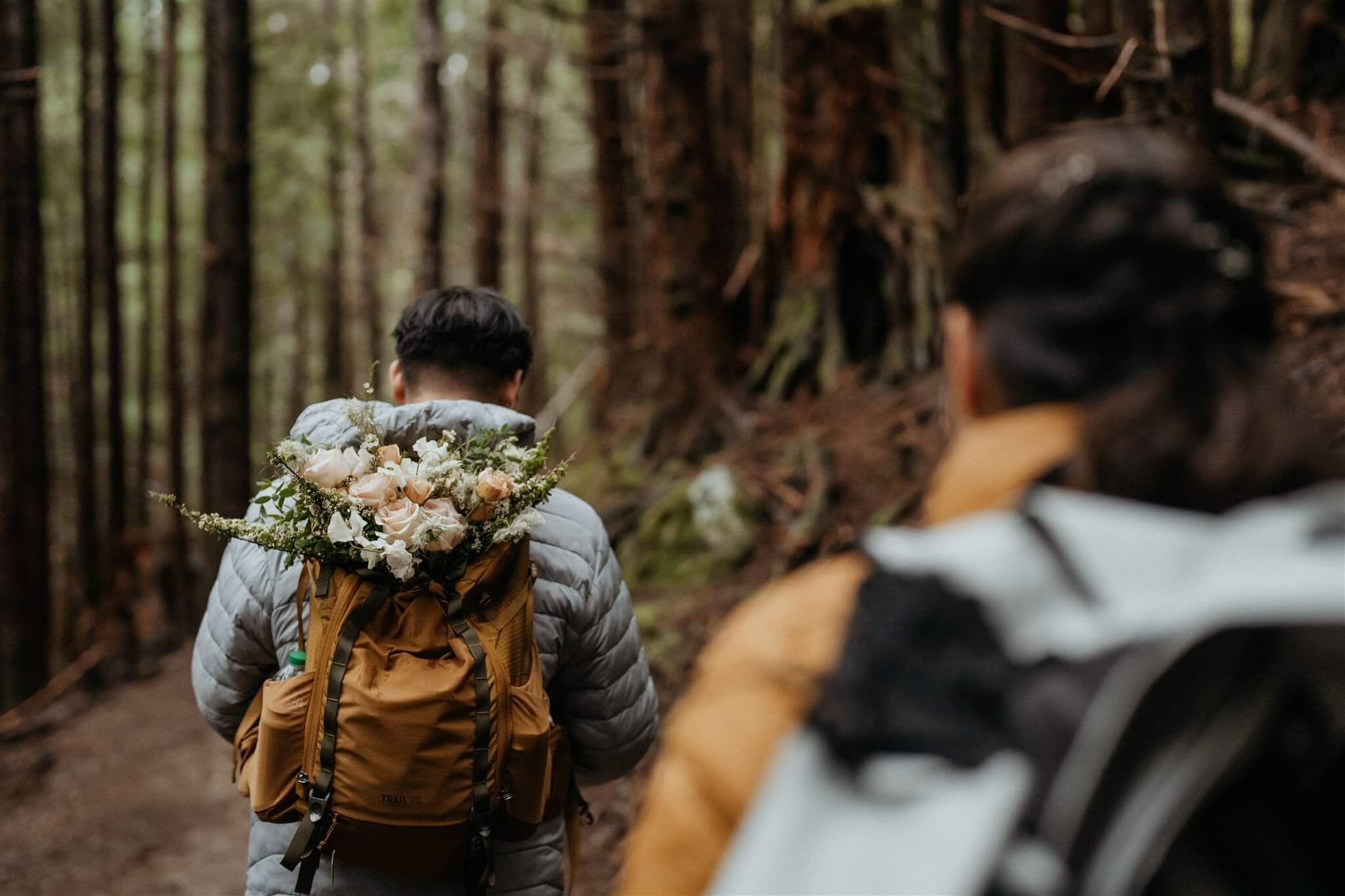 Bride and groom hiking through the forest to get to elopement ceremony location