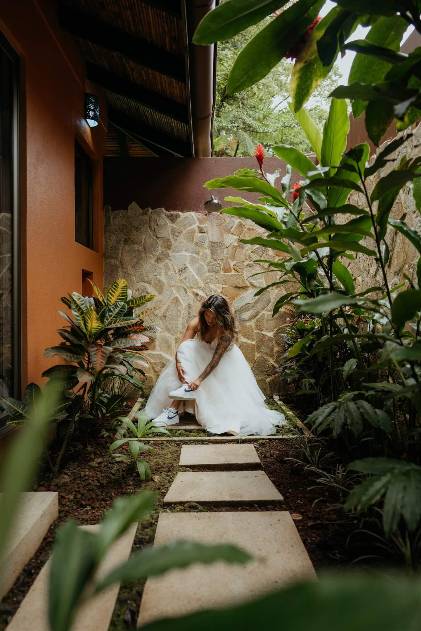 Bride putting on tennis shoes for adventure elopement in Costa Rica