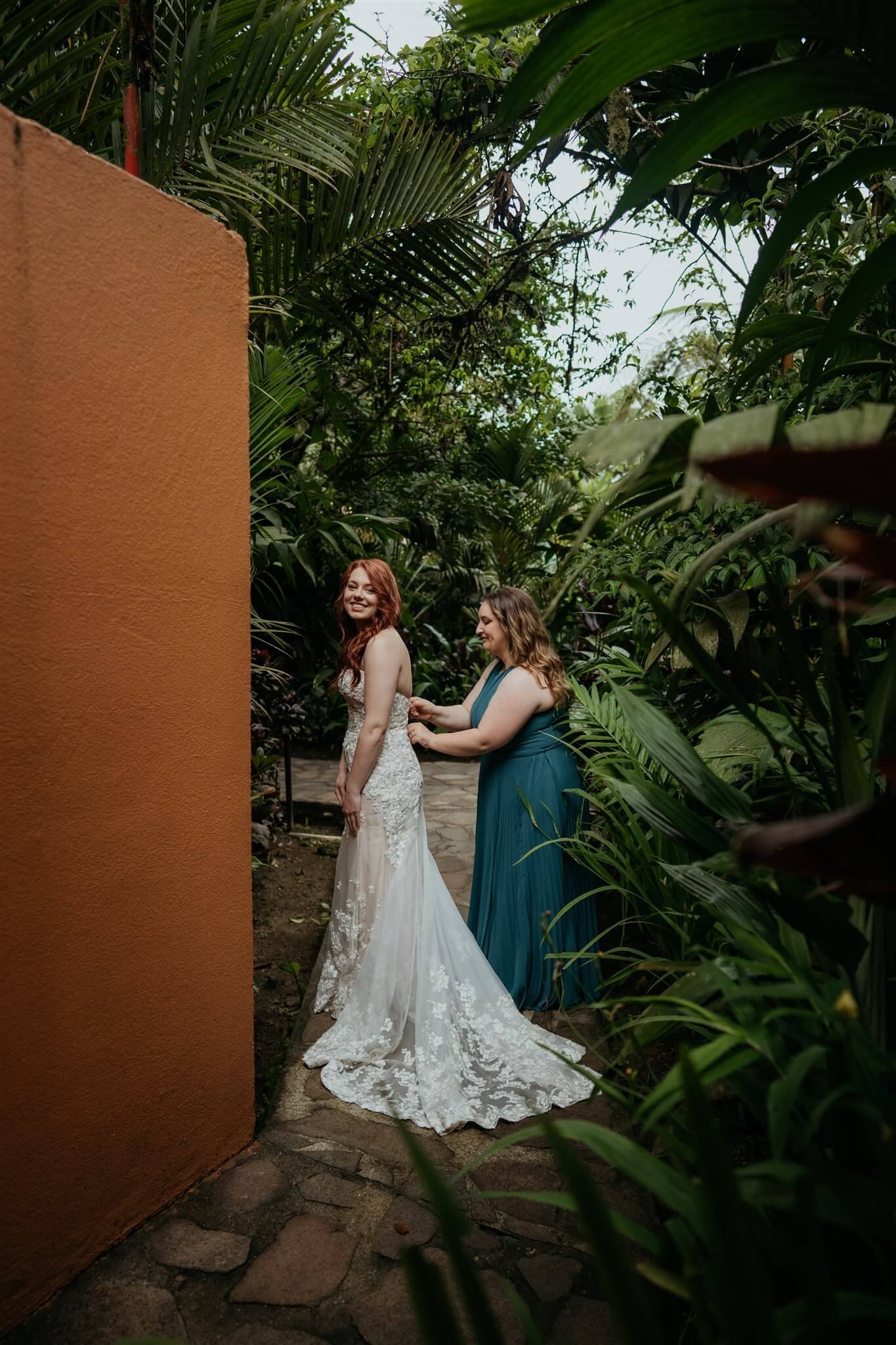 Bride getting into wedding dress for adventure elopement in Costa Rica