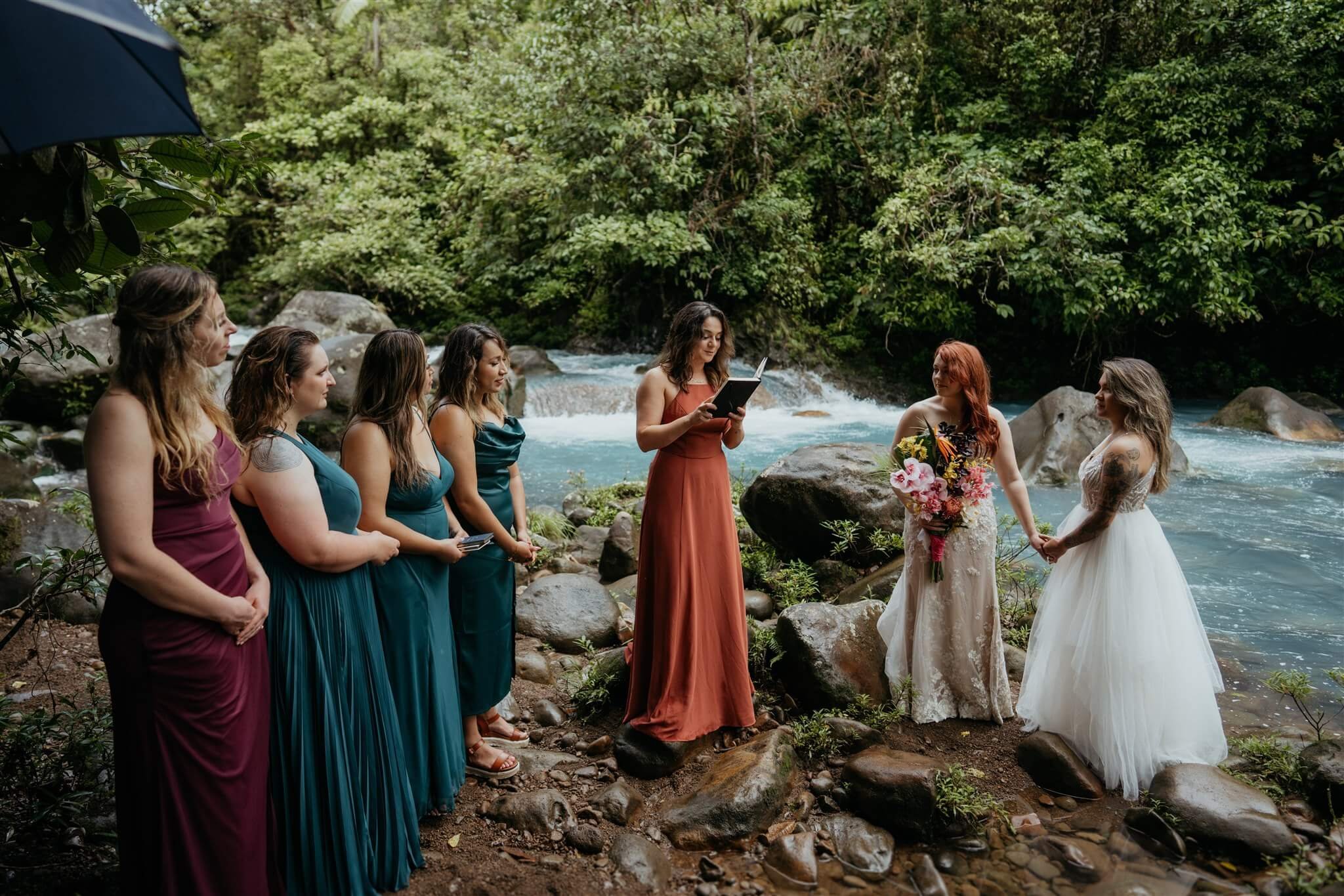 Brides hold hands during adventure wedding ceremony in Costa Rica