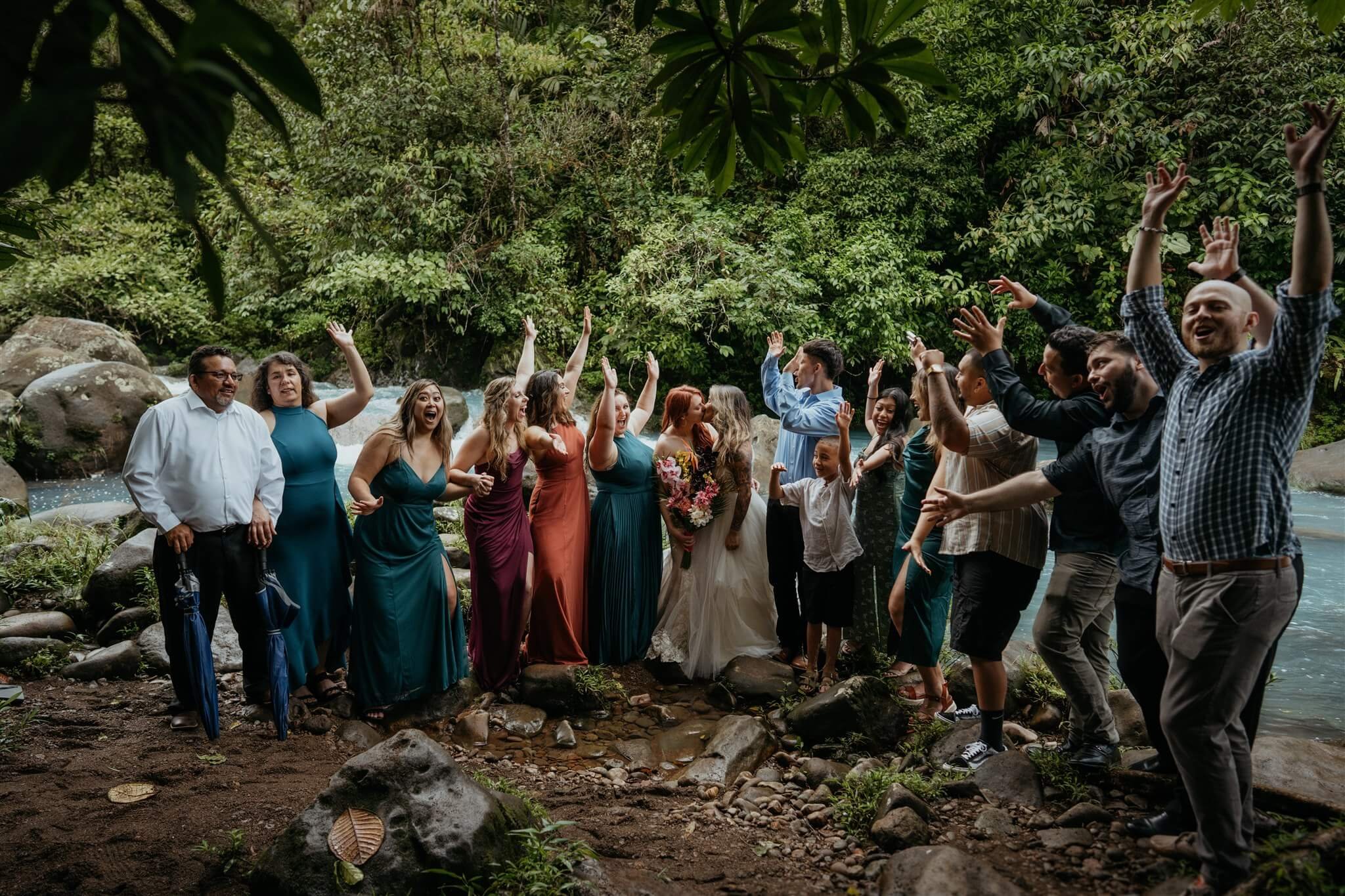 Guests cheer while brides kiss after adventure wedding ceremony