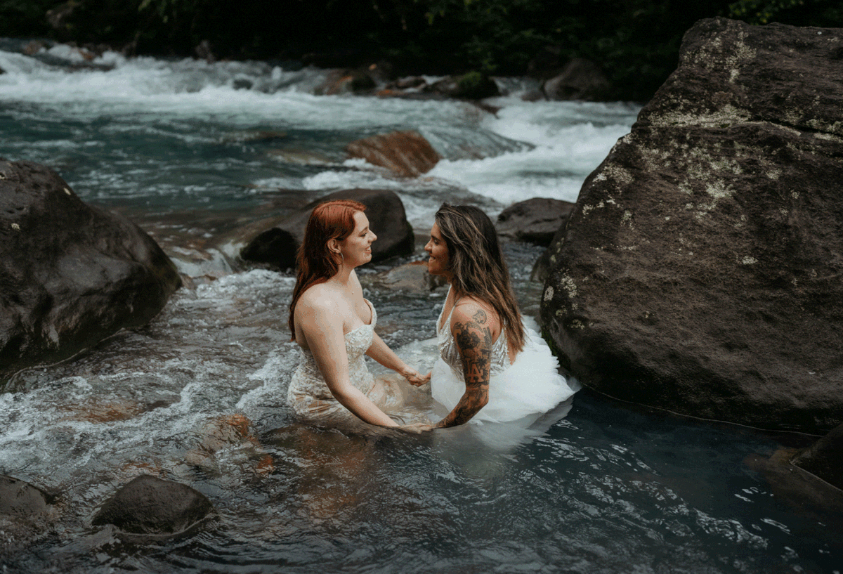 Two brides dip into the river during Cost Rica adventure elopement