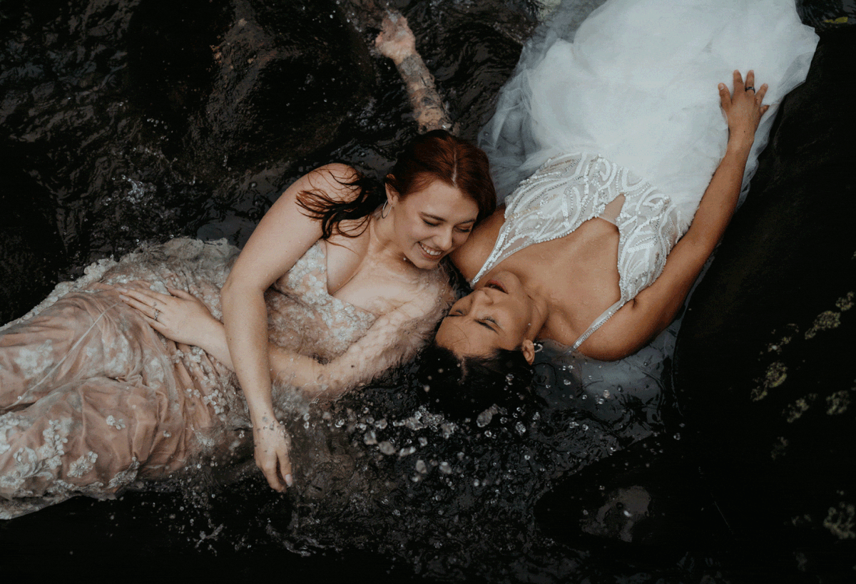 Two brides splash in the river at Costa Rica destination wedding