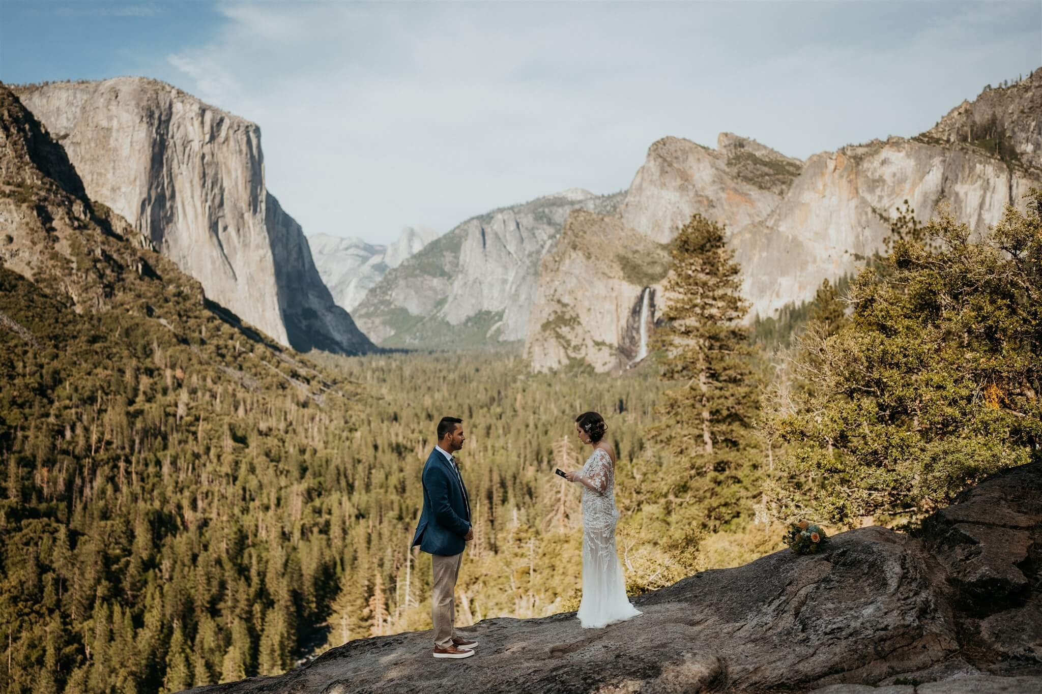 Bride and groom reading personal vows at Tunnel View