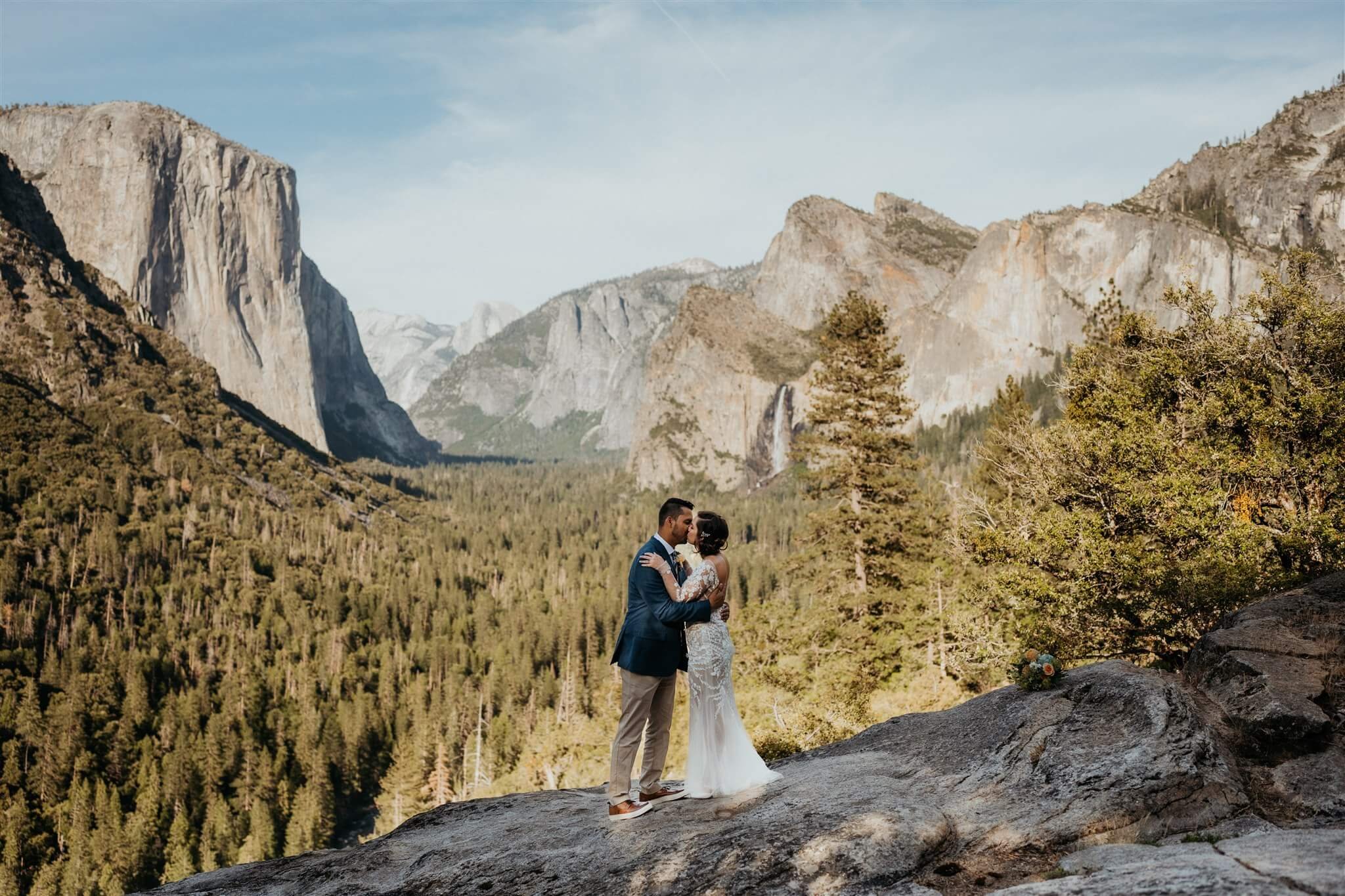 Bride and groom kiss after eloping in Yosemite at Tunnel View