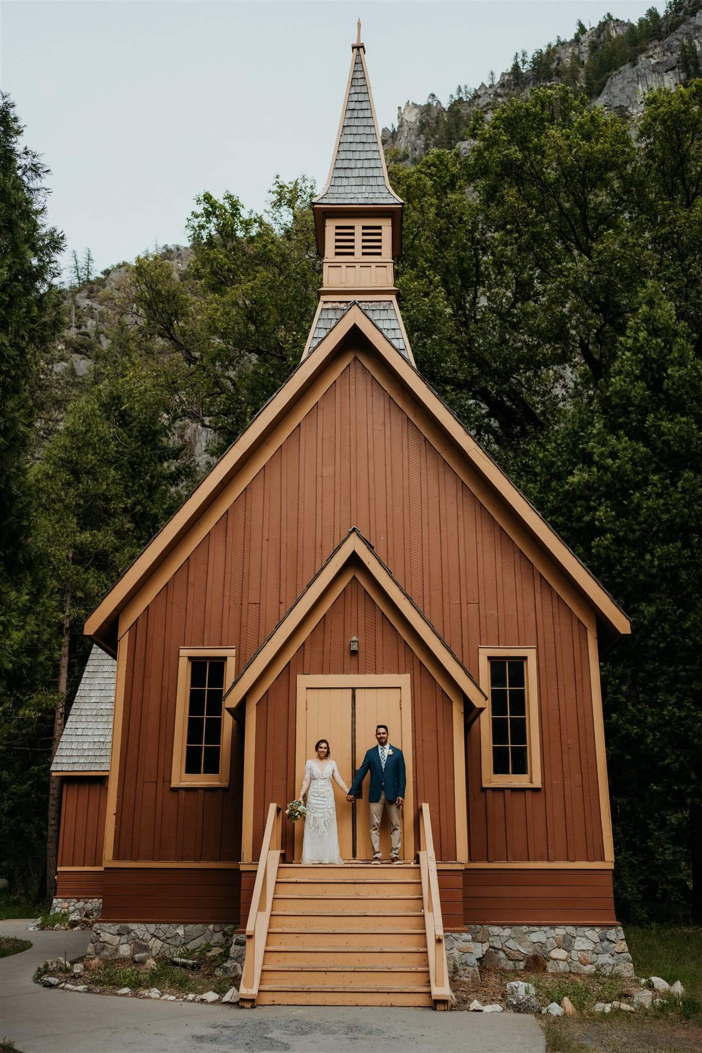 Bride and groom couple portraits in front of brown chapel in Yosemite National Park