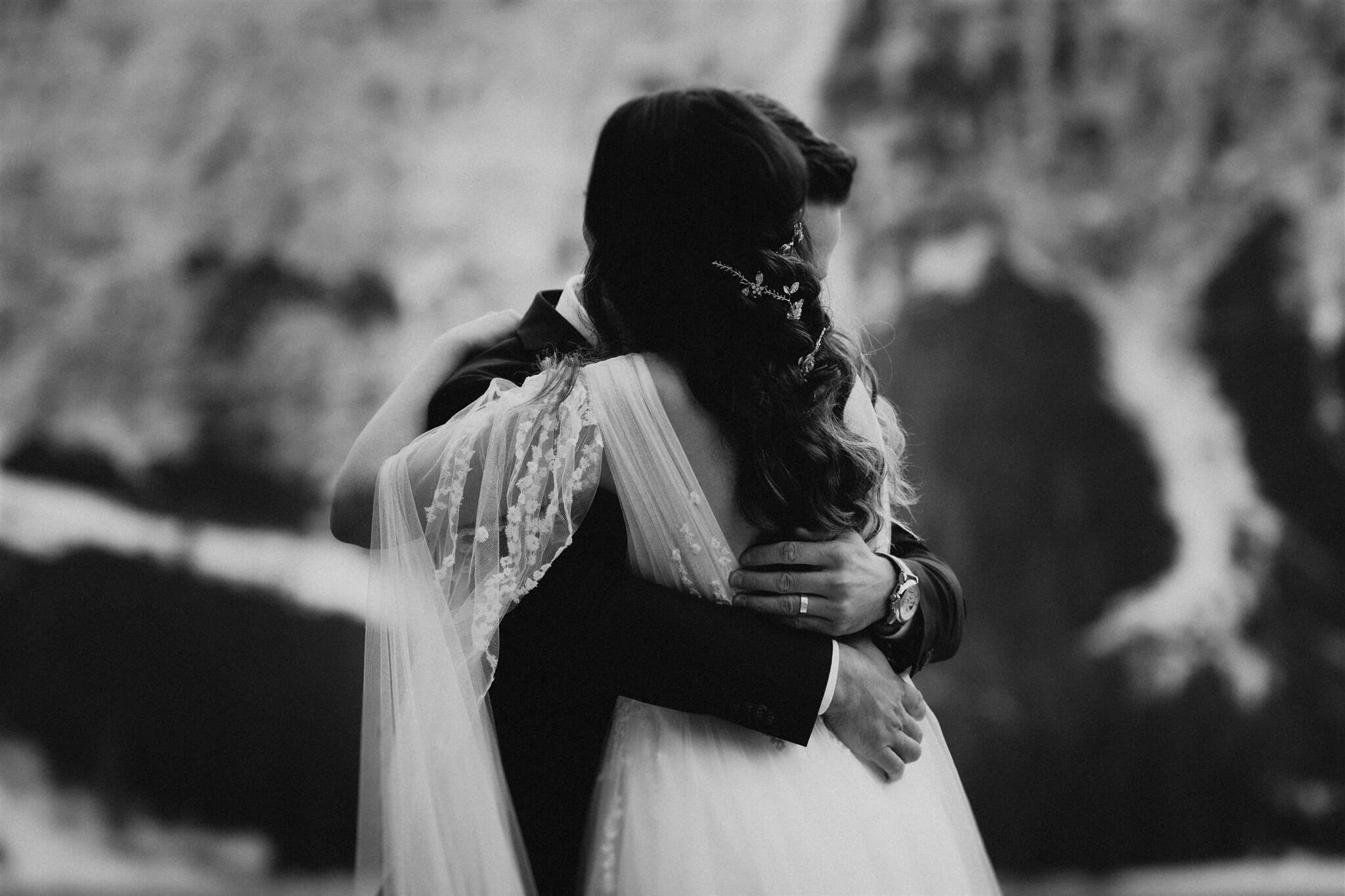 Bride and groom hug after exchanging vows by the lake at intimate vow renewal in Italy