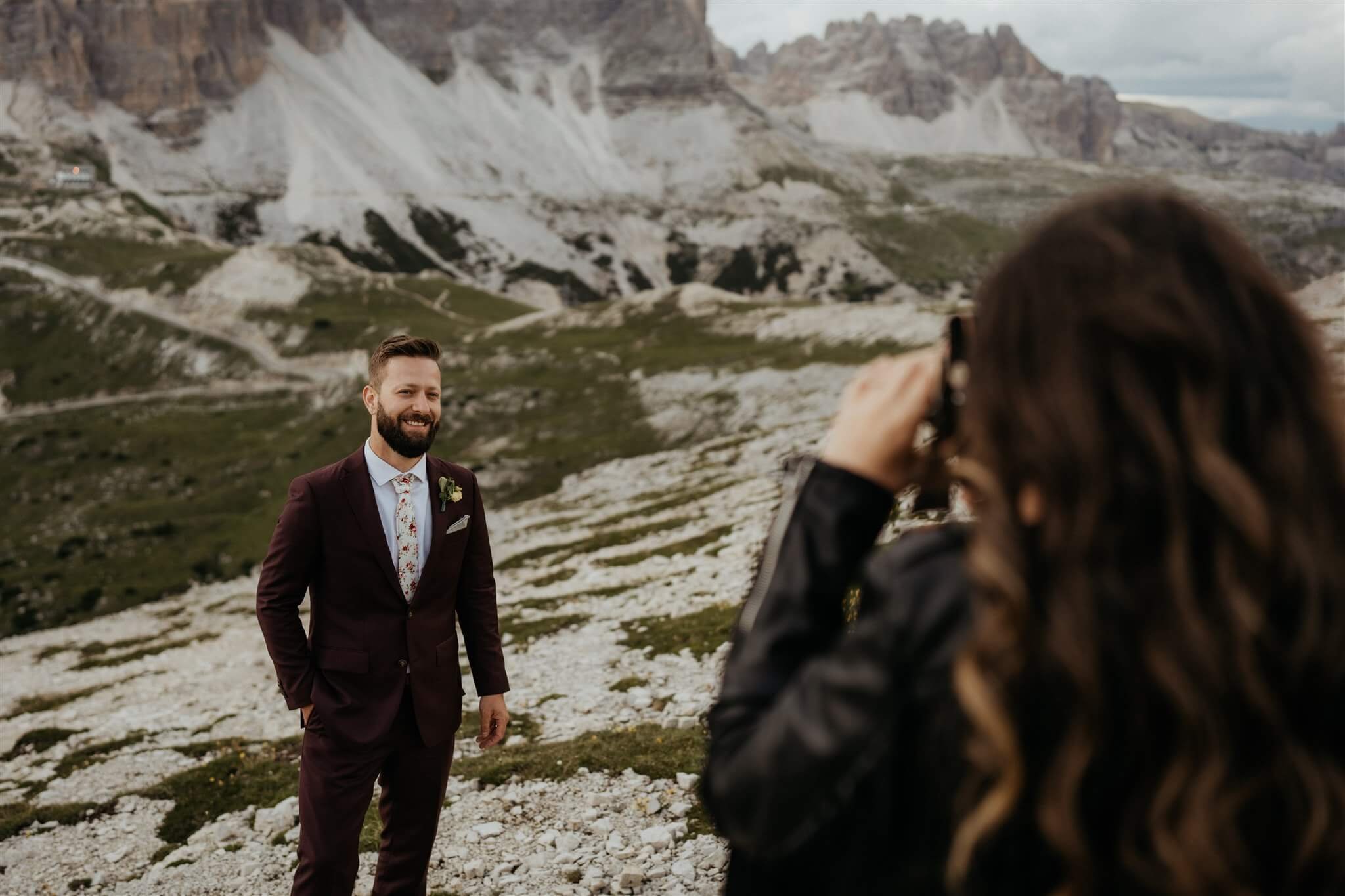 Bride taking photo of groom in the Dolomites during vow renewal elopement